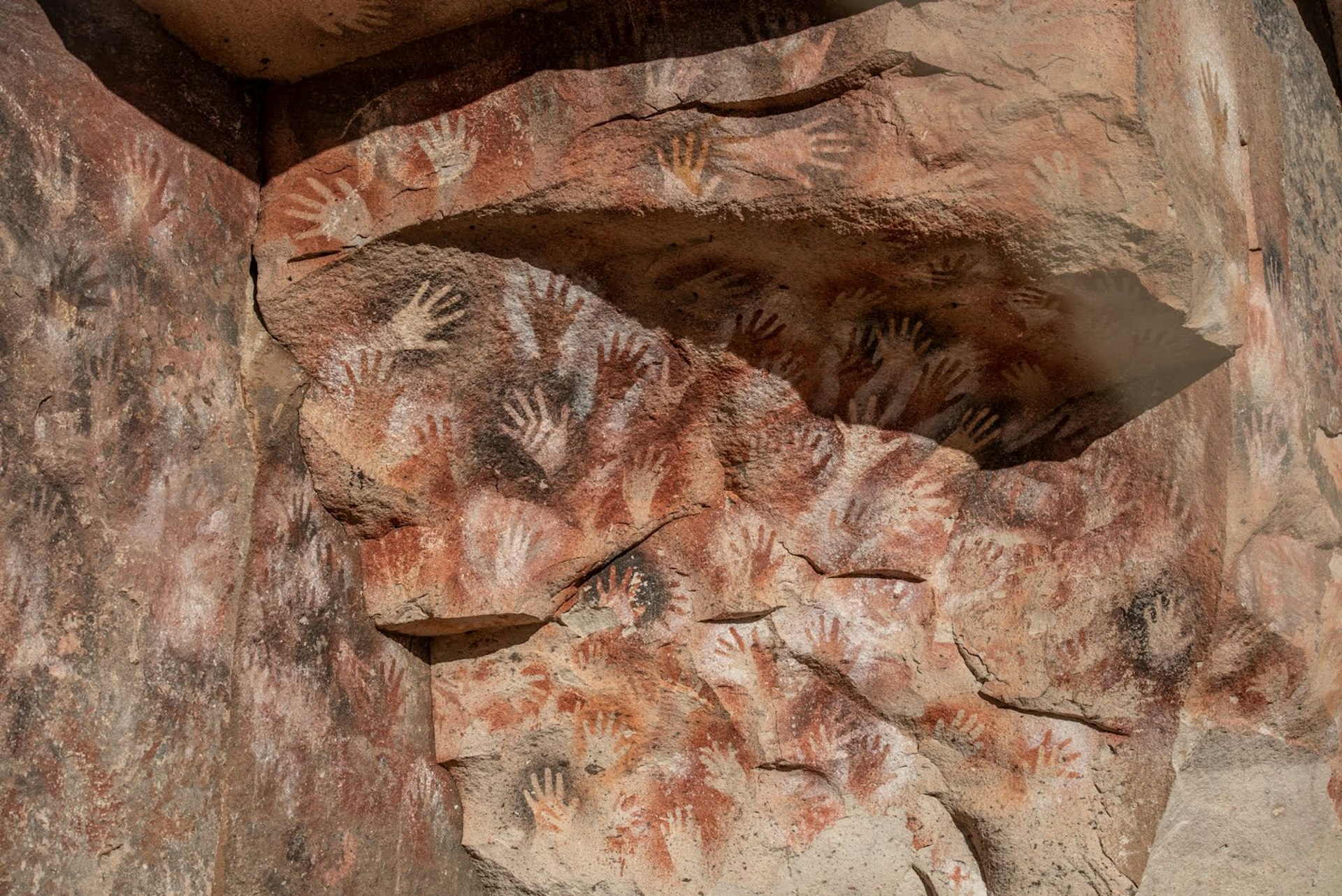 Ancient handprints in reddish tones decorate the walls of Cueva de las Manos in Argentina's Patagonia National Park