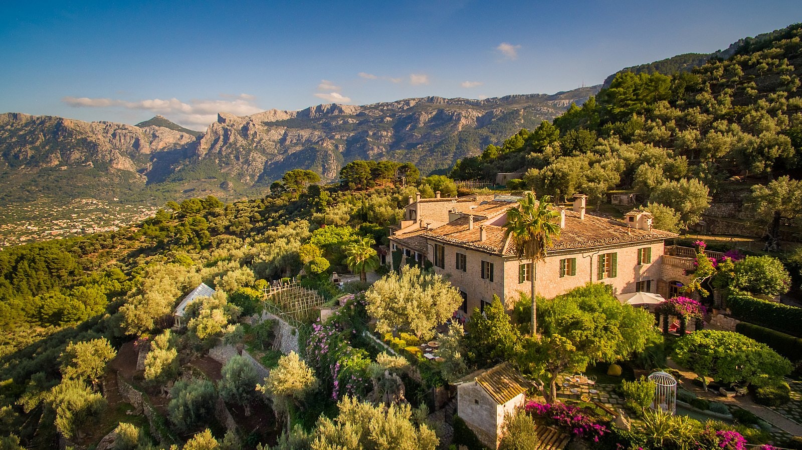 If you can't book the Love Island villa then book a stay at Ca's Xorc finca, a pinkish building set in a verdant garden with trees and pink flowers in a mountainous rural location.