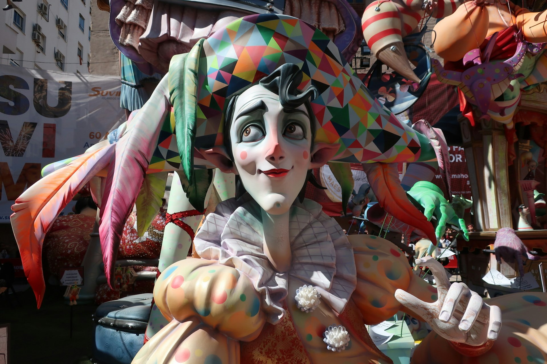 Close-up of a colourful falla sculpture of a clown wearing a large hat with feathers