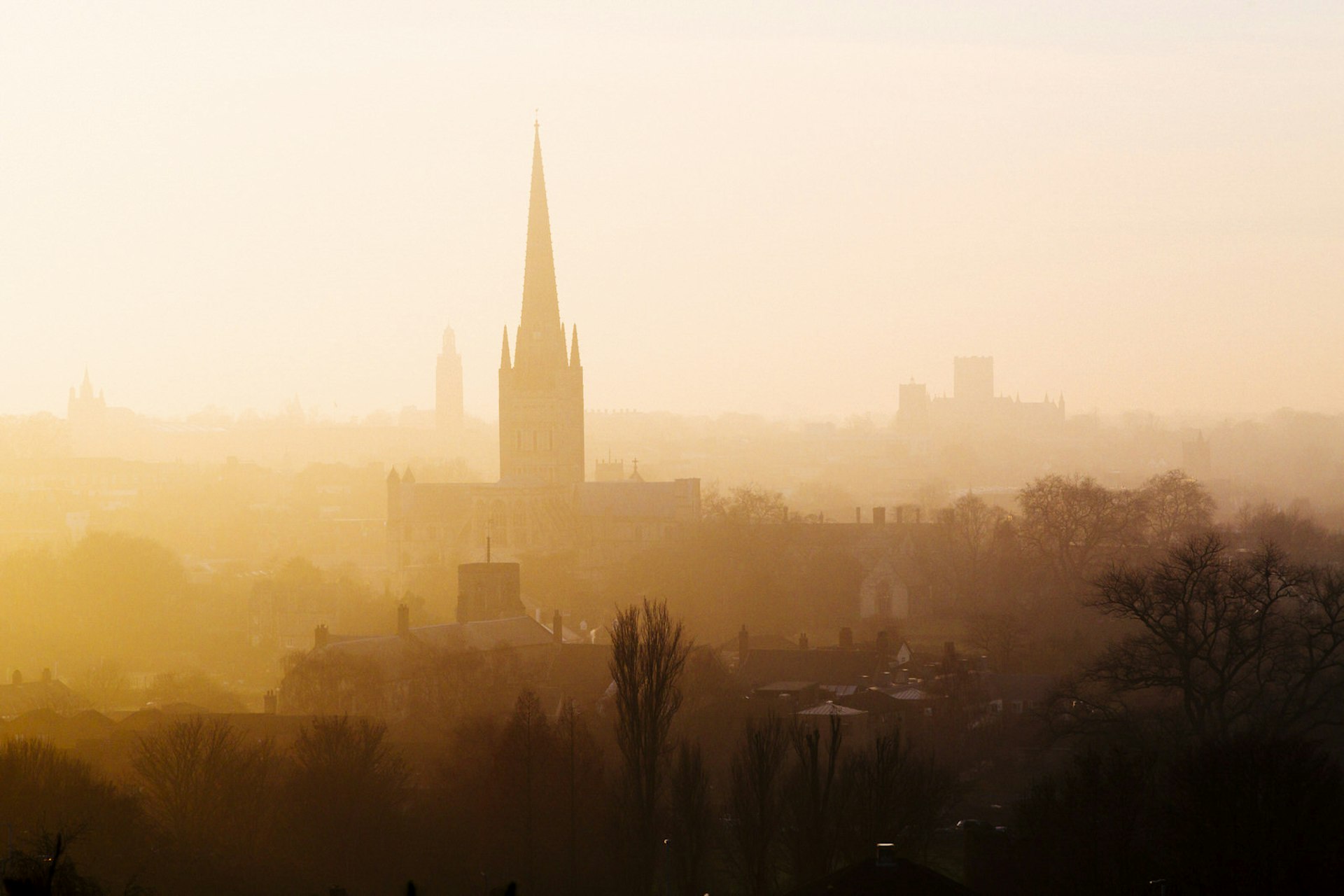 The silhouette of Norwich Cathedral's tower in mist, as seen from Kett's Heights.