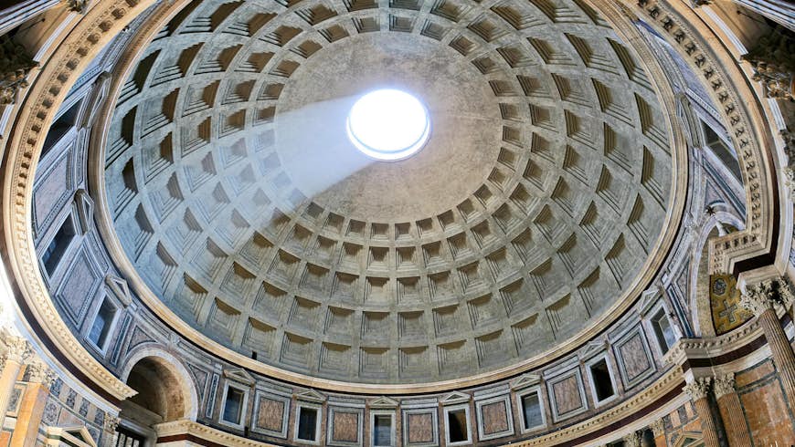 A beam of light breaks through the cirular hole atop the Pantheon's dome and cuts down into the building's interior