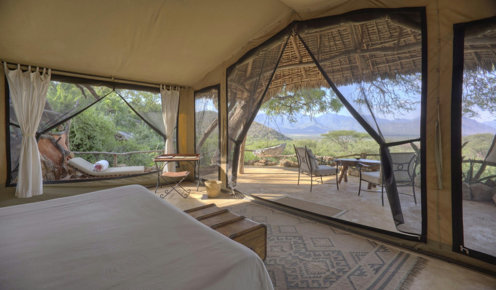 A luxury tent on a Kenyan field, with blue skies overhead; all-inclusive resort adventures