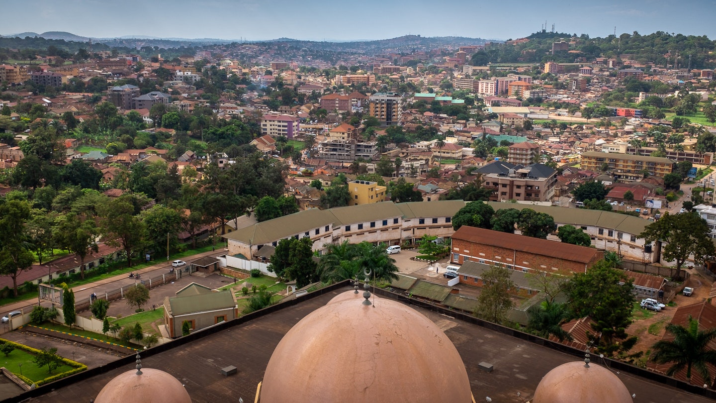 Looking down over three domes (the biggest in the middle, flanked by two smaller ones) atop the Old Kampala National Mosque; in the distance below are the red roofs carpetting the hills of Kampala