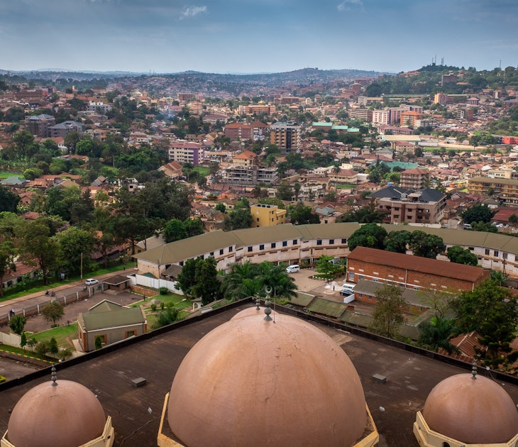Looking down over three domes (the biggest in the middle, flanked by two smaller ones) atop the Old Kampala National Mosque; in the distance below are the red roofs carpetting the hills of Kampala