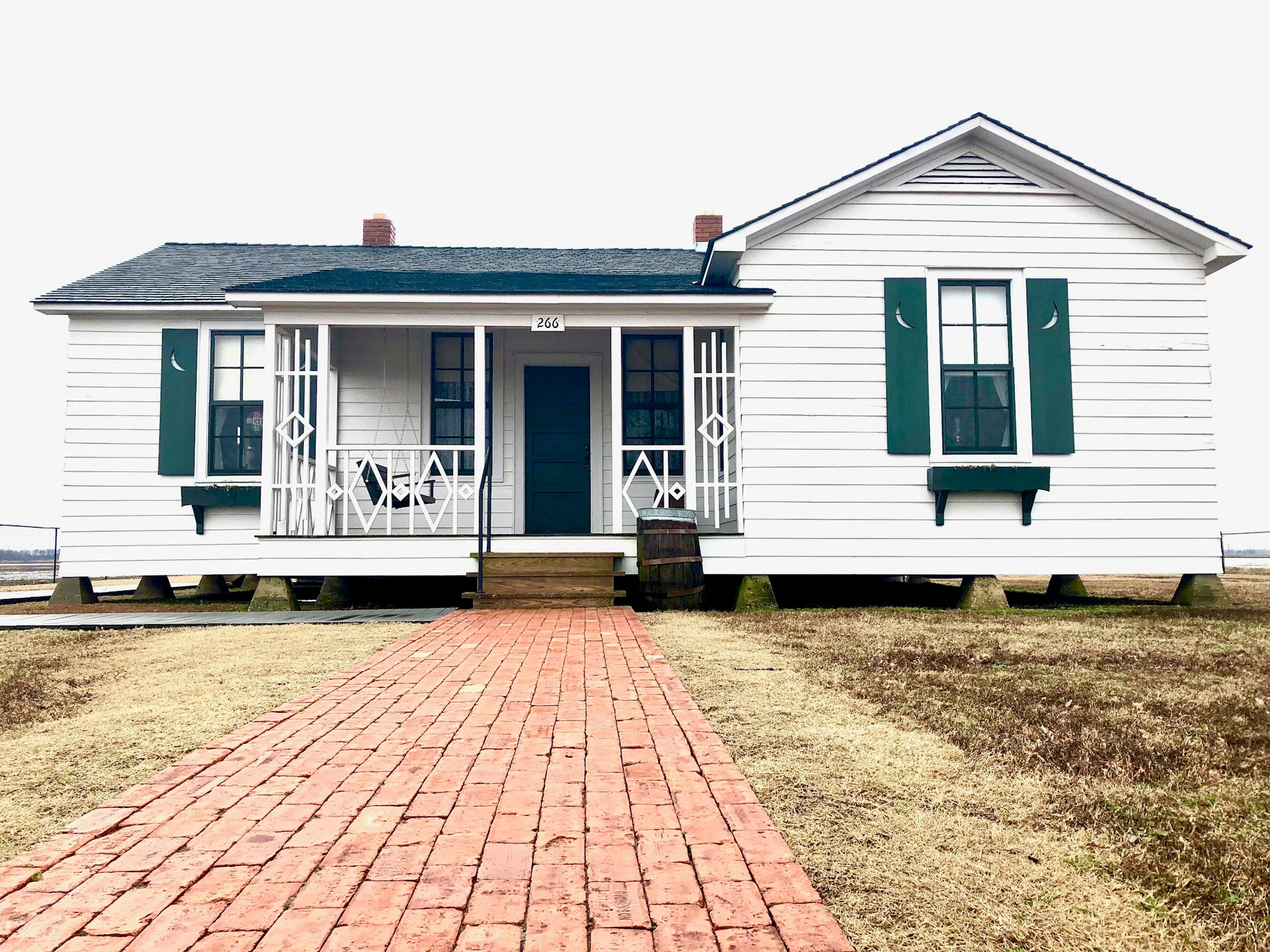 Johnny Cash's boyhood home, a white farmhouse with a front porch swing