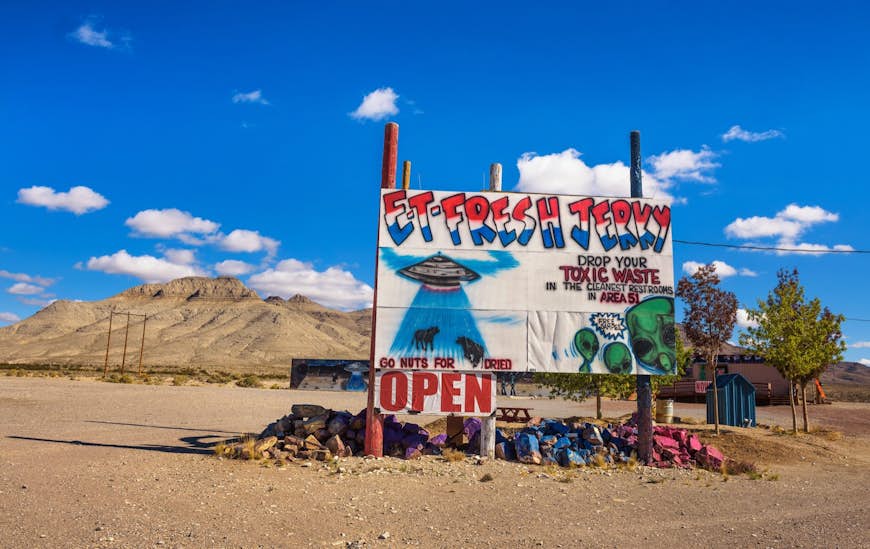 A sign advertising ET Fresh Jerky on the side of a deserted road; area 51