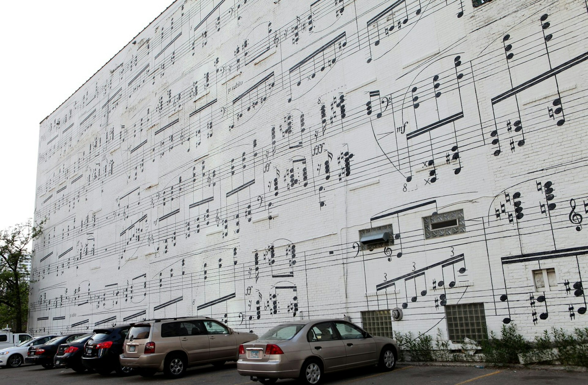 A musical mural on the side of the Schmitt Music Building: the artwork resembles a giant sheet of music, with black music notes painted onto a white background