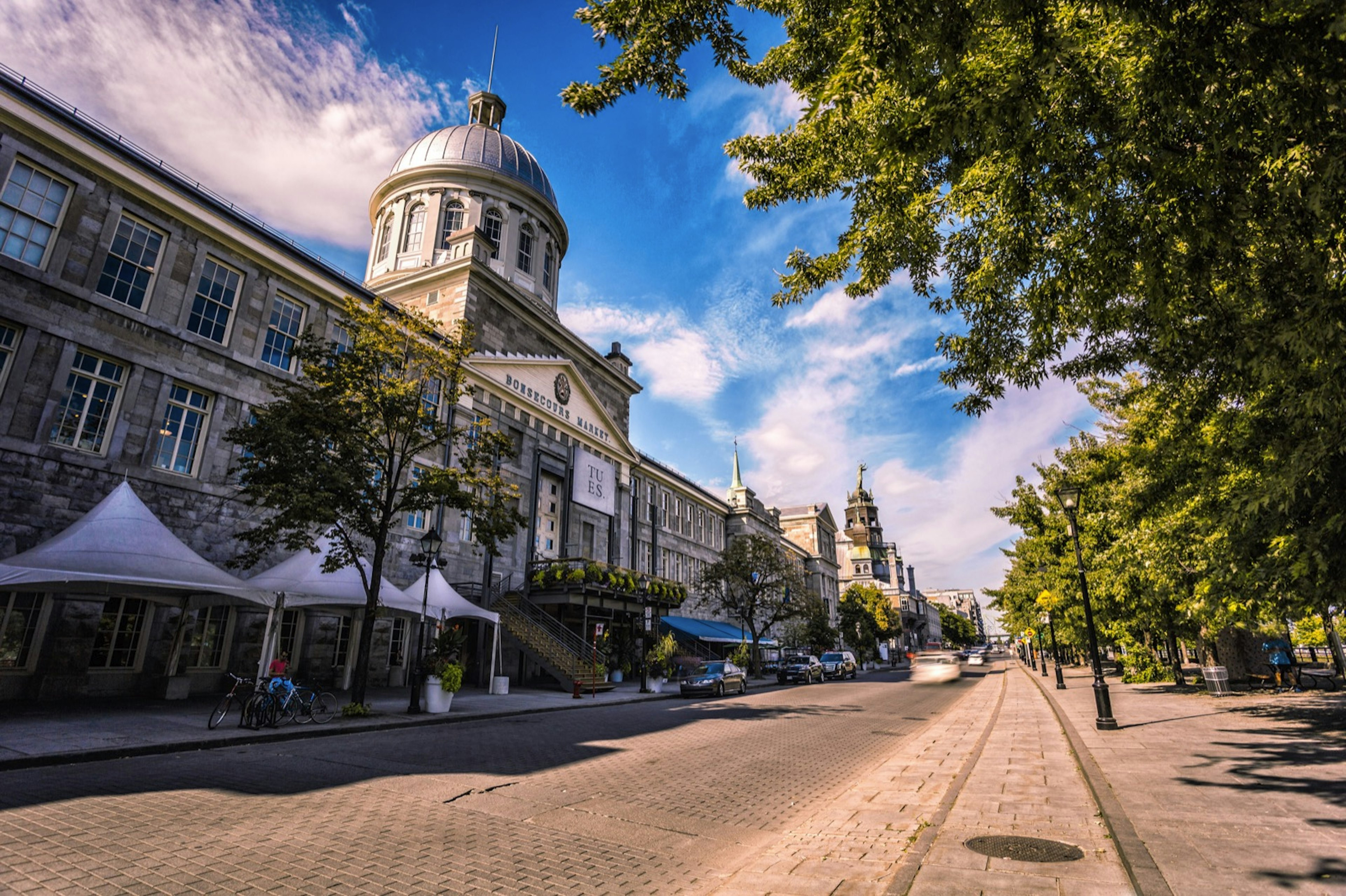 The Bonsecours Market of Montreal sits along a cobblestone street on a beautiful clear day