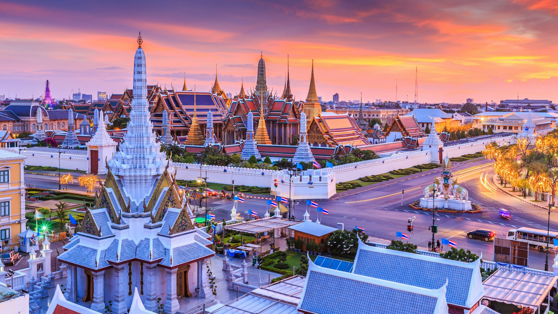 The sun sets over Wat Phra Kaew (Wat Phra Si Rattana Satsadaram or Temple of the Emerald Buddha) and the Grand Palace