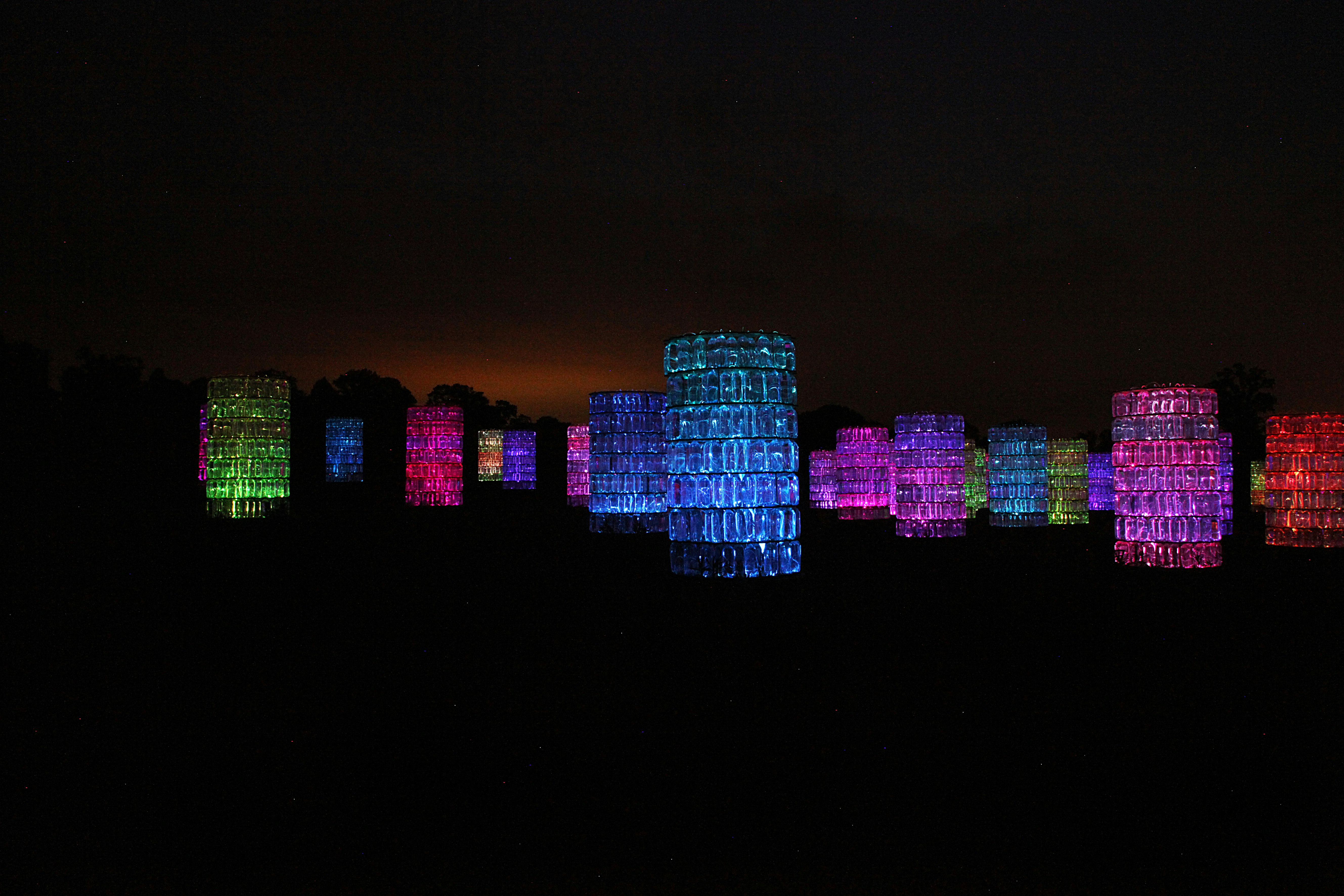 A cluster of water towers illuminated with multicolored lights