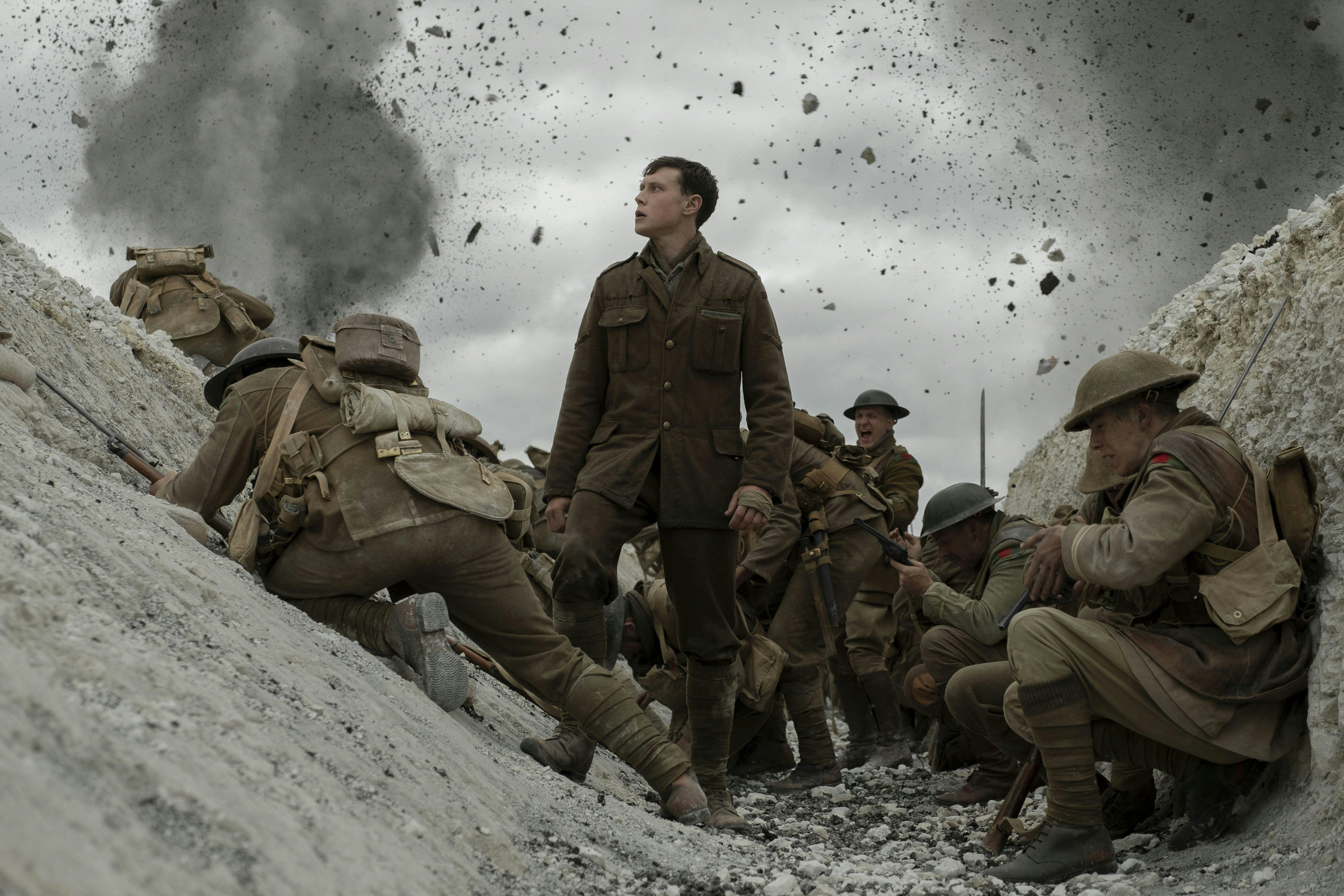 A still from the movie '1917': actor George MacKay stands in the trenches with other troops as they're being shelled.
