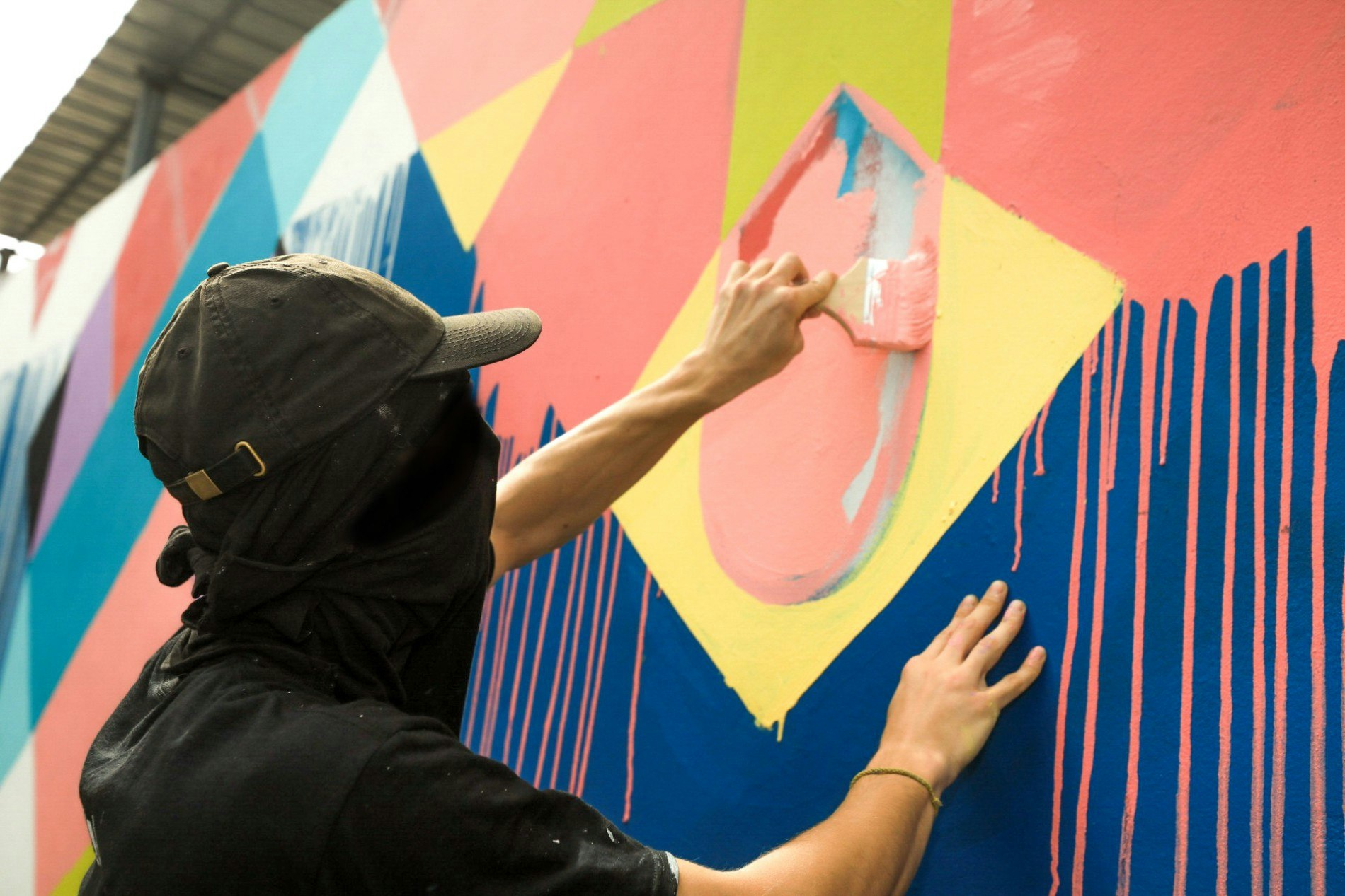 A person from the 1UP Collective painting a mural