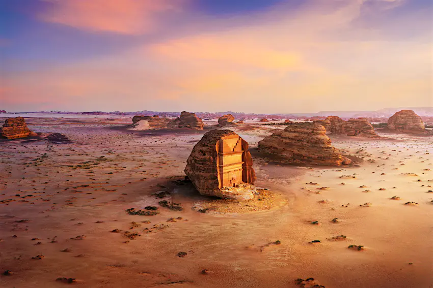 Maiden Saleh A golden-coloured tomb carved into rockface in the middle of a desert landscape