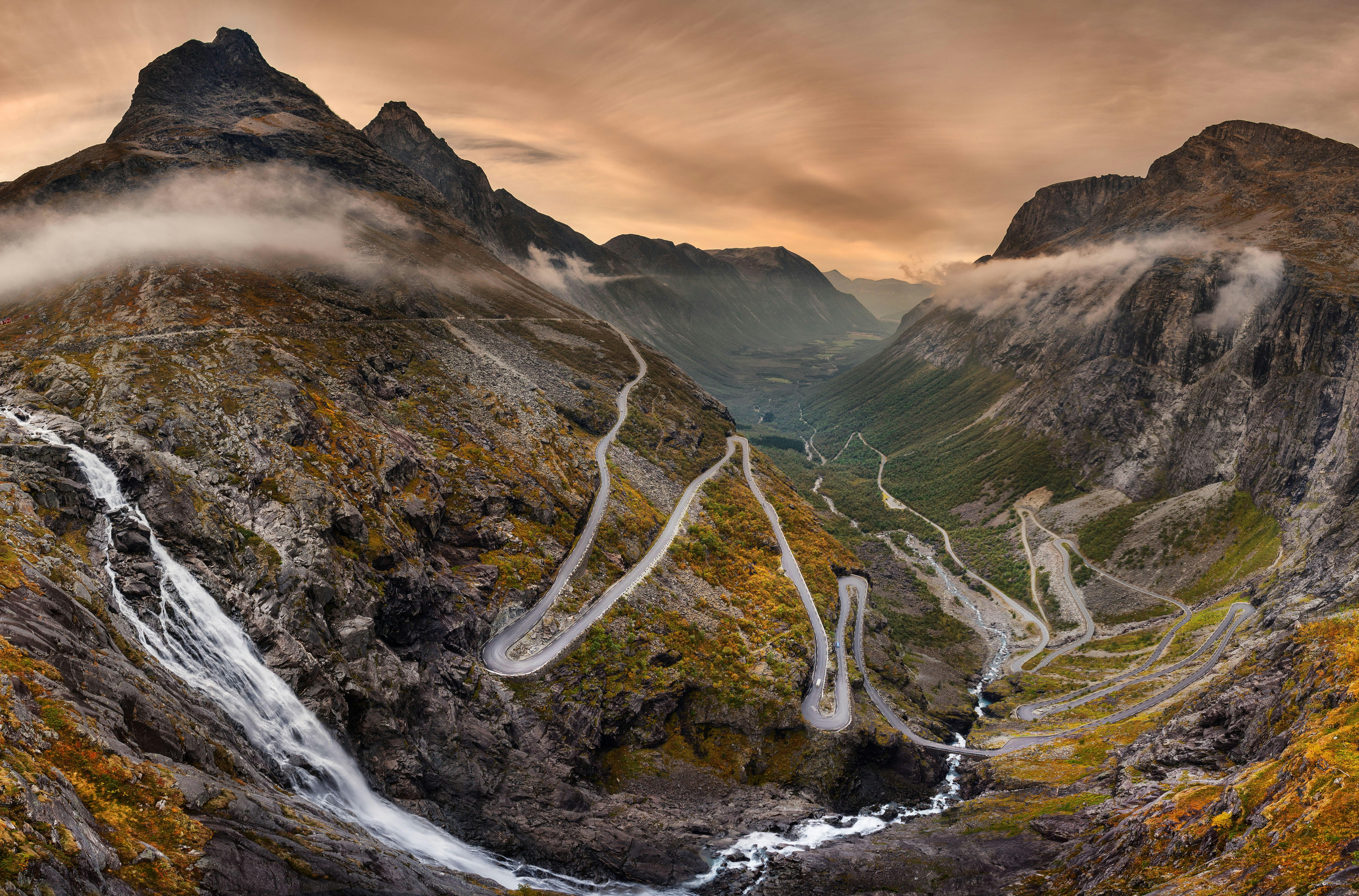 A light fog is over the Trollstigen twisty mountain road, in Norway, at dusk. 