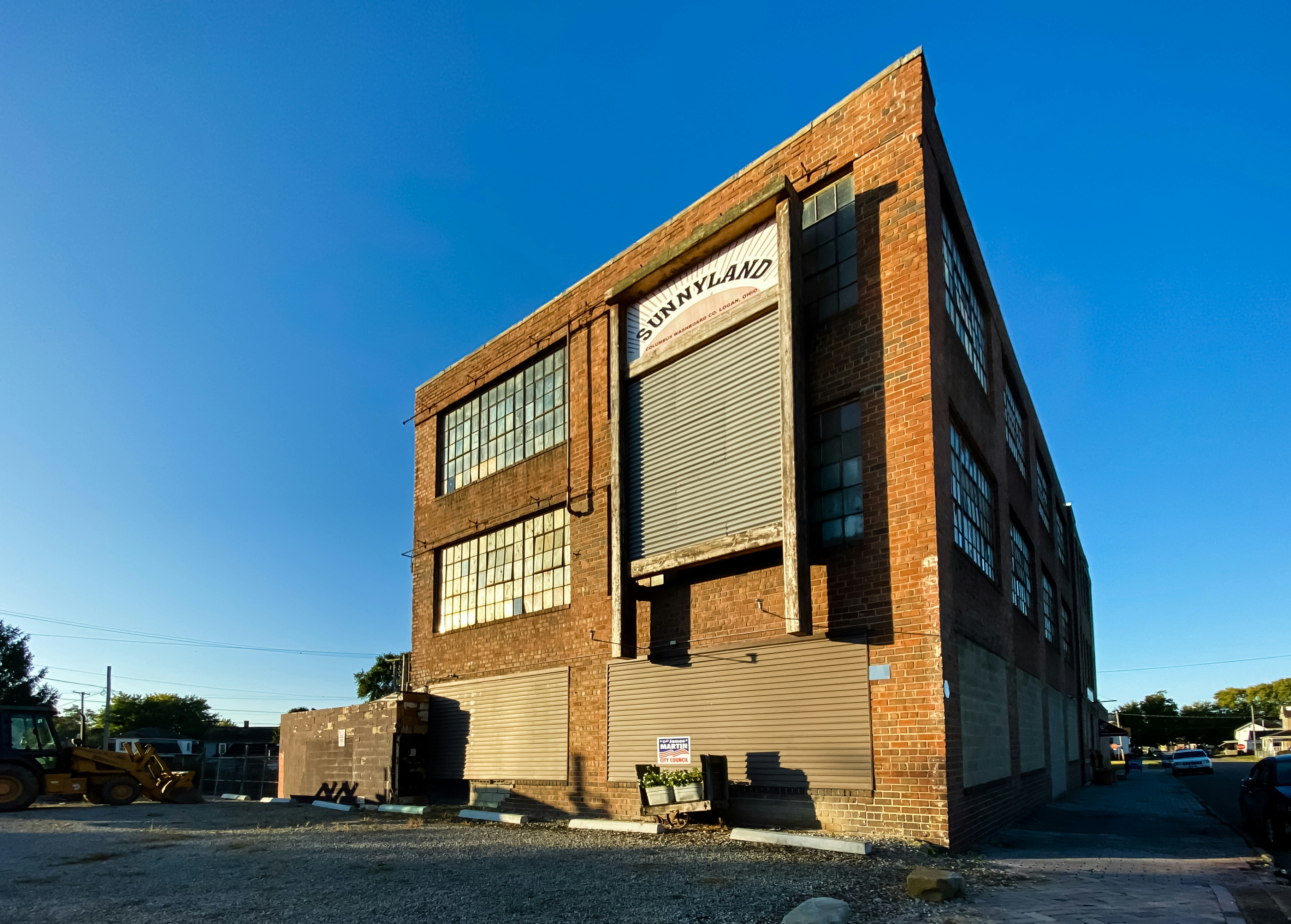 The brick and glass industrial exterior of the Columbus Washboard Factory is decorated with the world's largest washboard, a two-story version of the classic laundry devise with the words "Sunny Land" painted on the top with a sunbeam motif. 