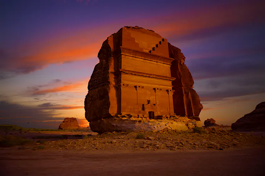 Qasr Al Farid A large tomb carved into a giant honey-coloured standalone rock at sunset