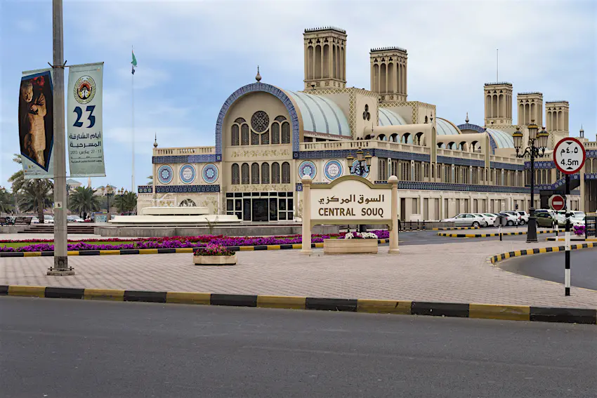 central_souk_sharjah.jpg A wide-angle shot of a huge sandy-coloured building which is accented with decorative blue tiles. Outside is a sign that reads "Central Souk" in both Arabic and English.