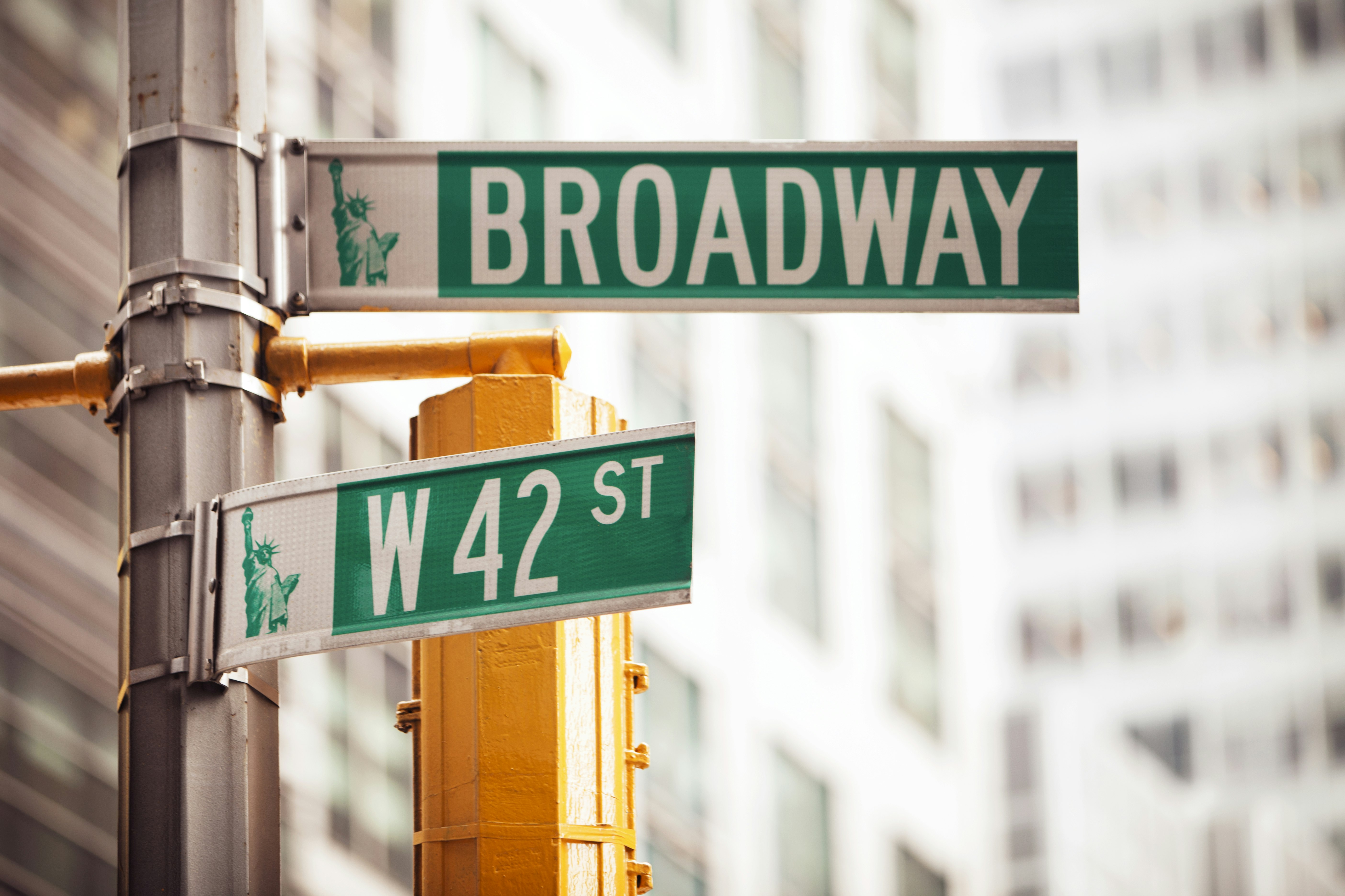 Street signs reading the intersection of 42nd St and Broadway