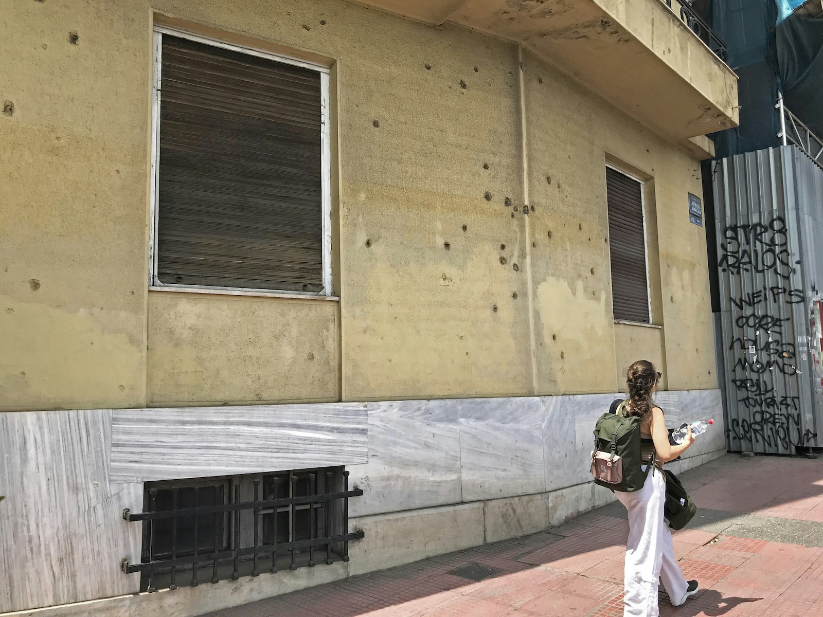 A scattering of bullet holes in the wall of the building on 43 Amalias