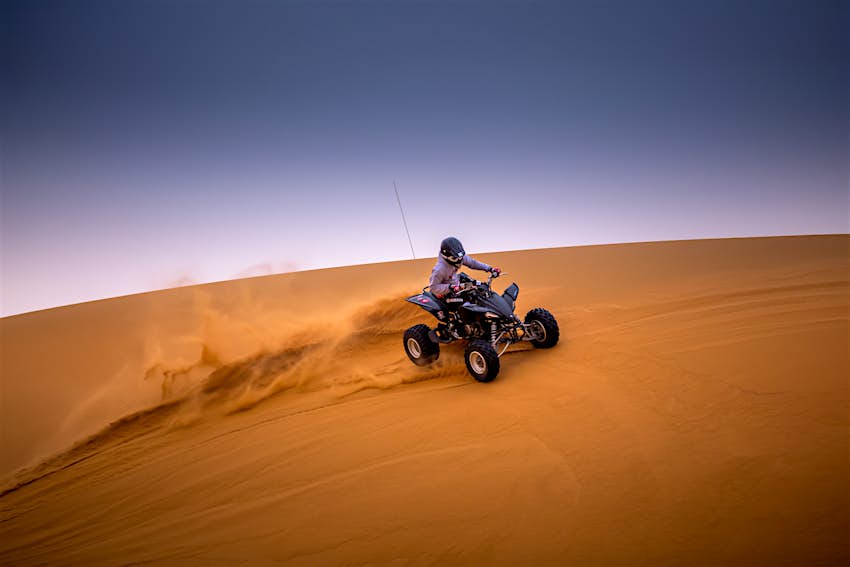 Al Nafud Desert A person on a 4x4 riding the golden dunes of Al Nafud Desert