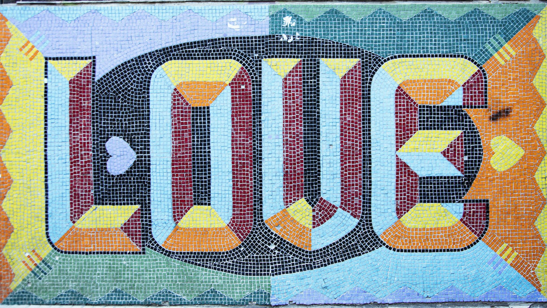 A colourful tiled mural with 'Love" written in block letters