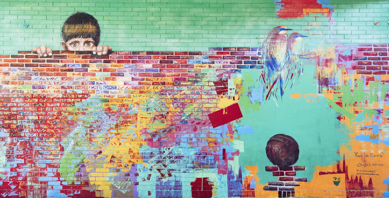 A colorful mural depicting a boy peeking over a wall