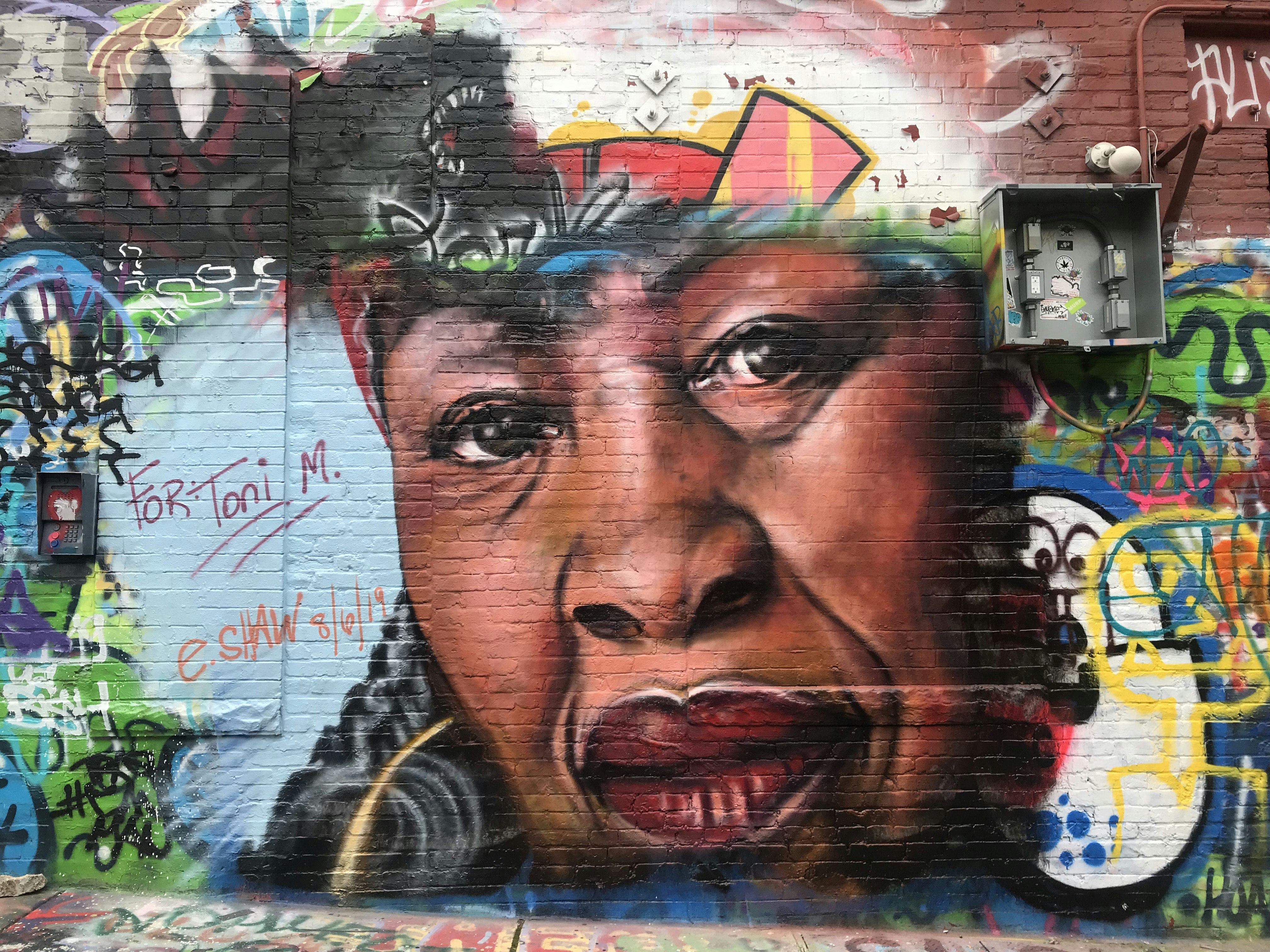 A colourful spray-painted mural of Toni Morrison