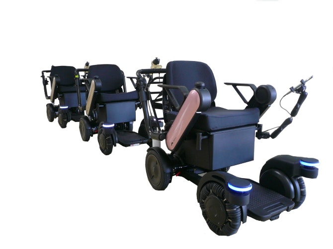 Three of ANA's new self-driving wheelchairs in a line