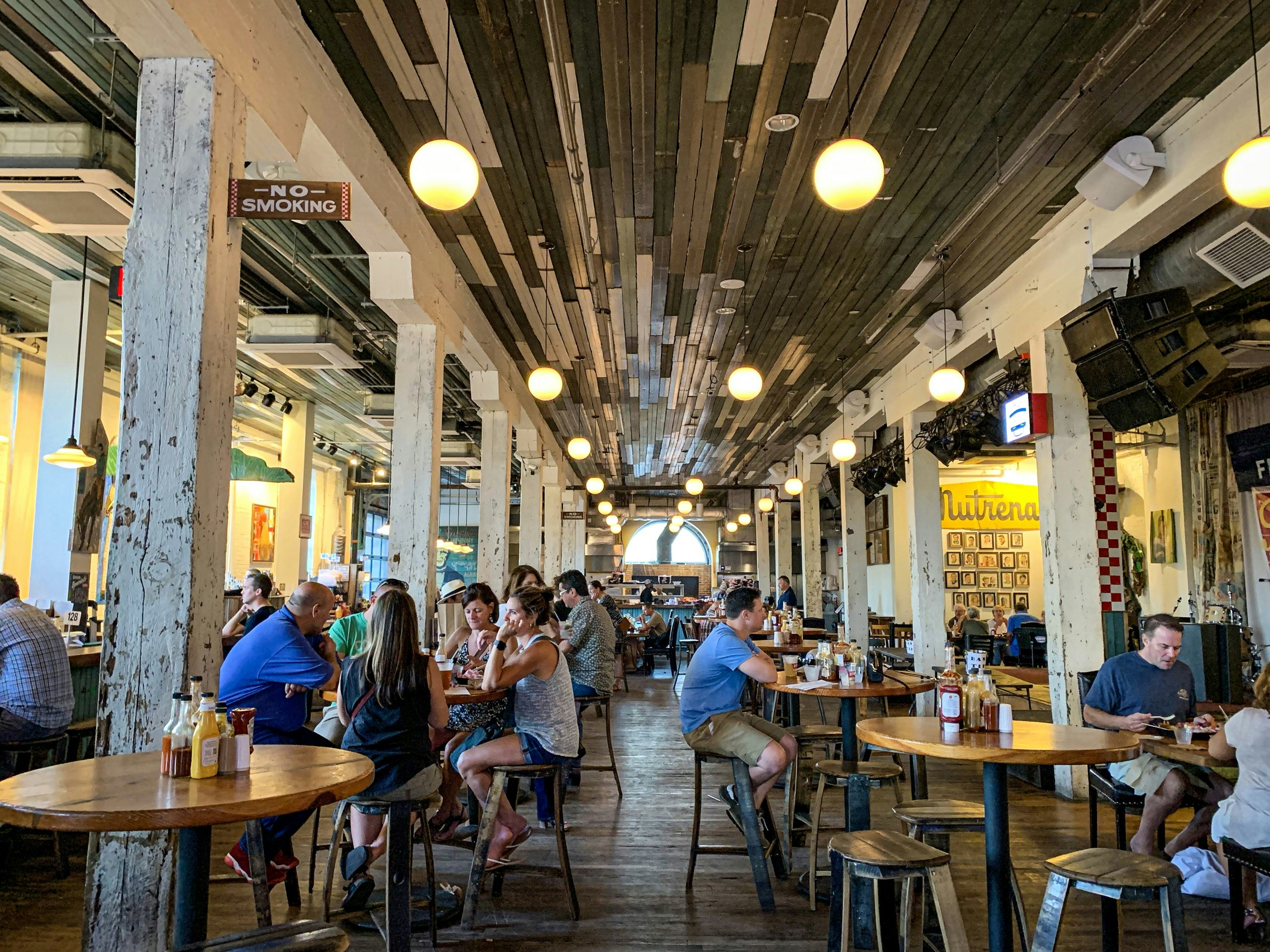 Patrons enjoy the bright sunshine at Acme Feed and Seed, a bar, restaurant and music venue; best country music venues in nashville