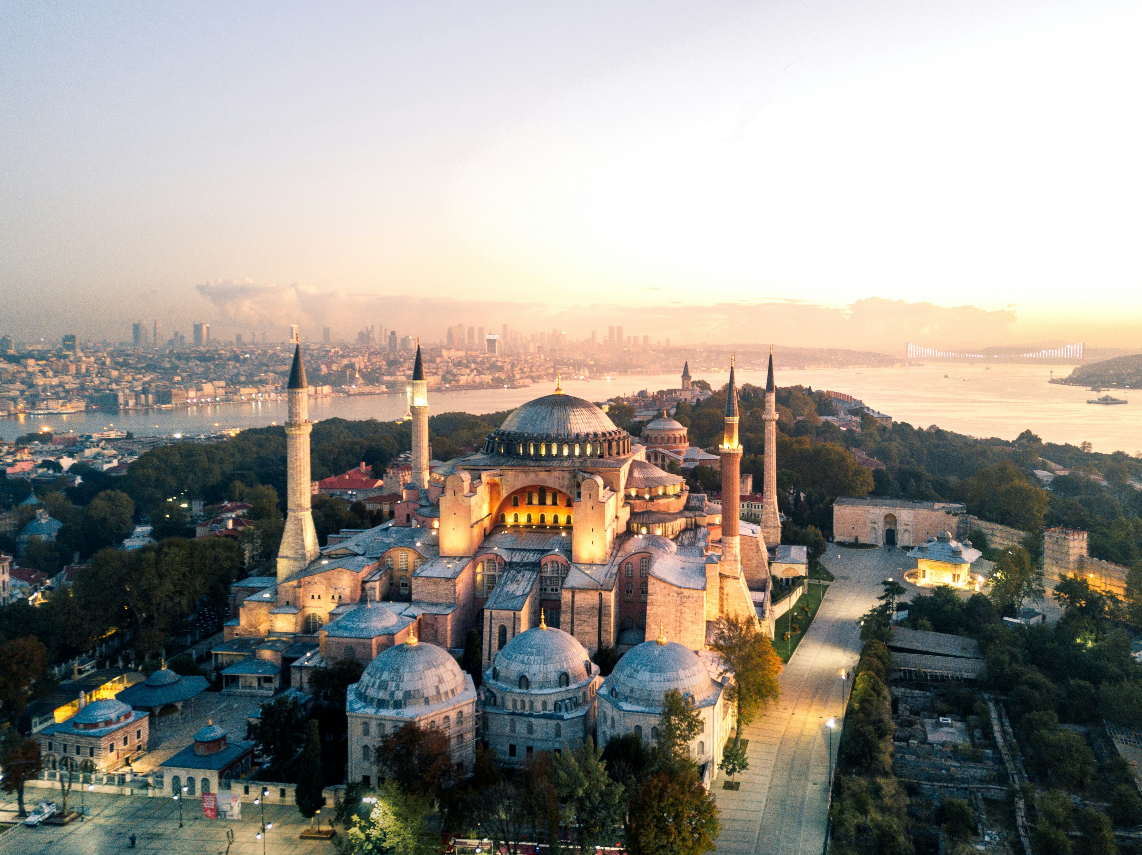 An aerial view of the Hagia Sophia mosque in Istanbul; the photo is taken at dusk, and lights are beginning to illuminate the city.