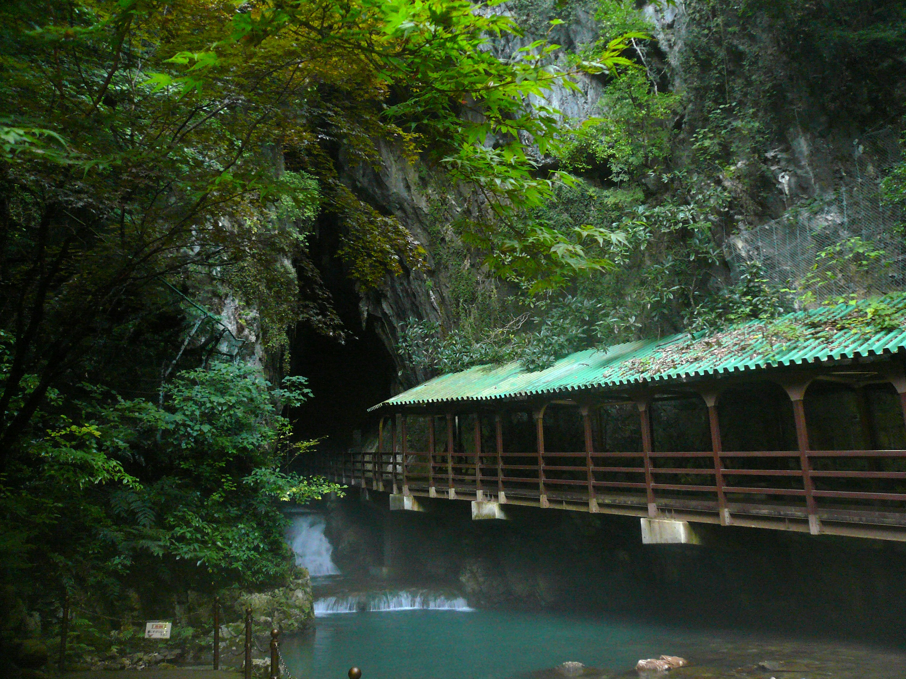 A bridge covered in green roof tiles leads into the Akiyoshidai cave, the longest in Japan, in the Akiyoshiidai National Park in Yamaguchi Prefecture's karst plateau