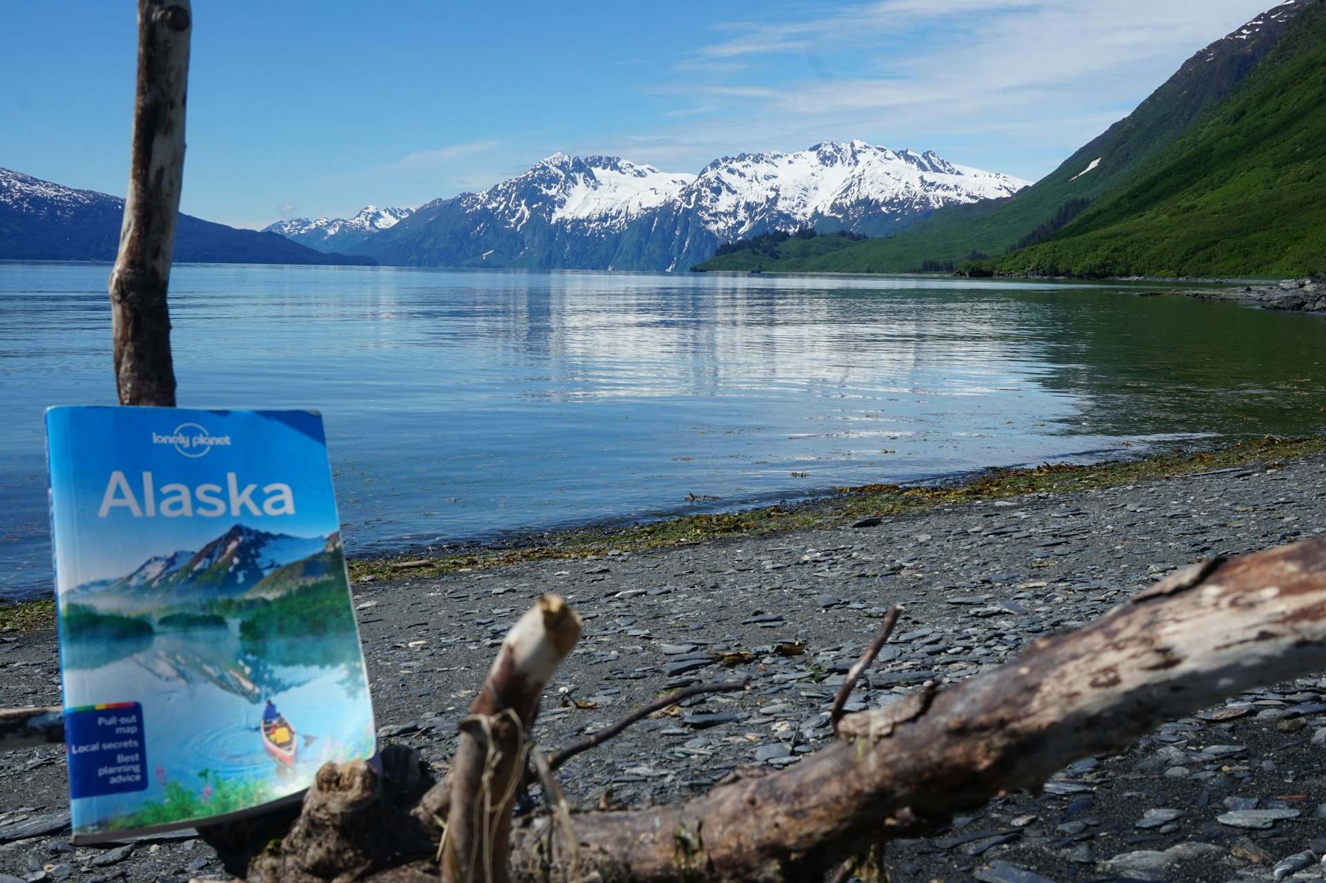 An Alaska travel guide posed in front of a bucolic scene from Alaska