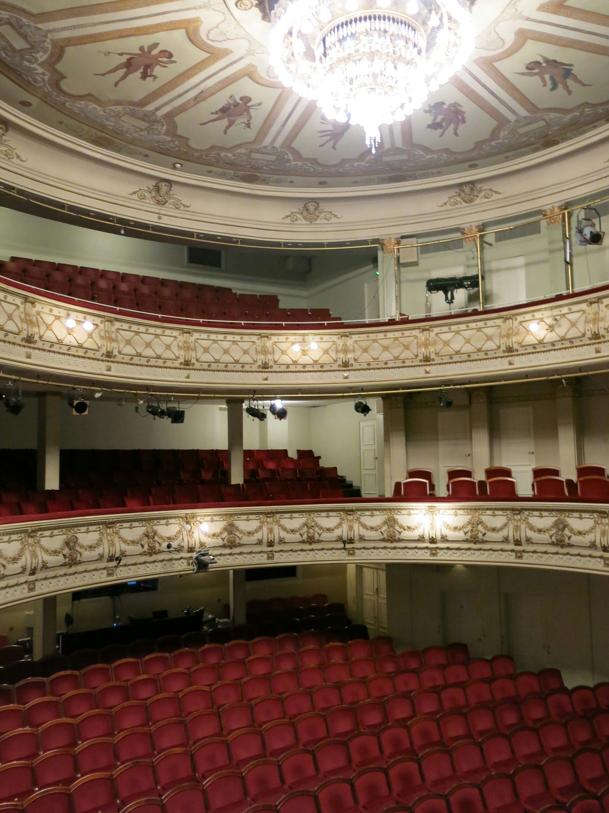 A vertical image of the Alexander Theatre hall with three storeys and red chairs