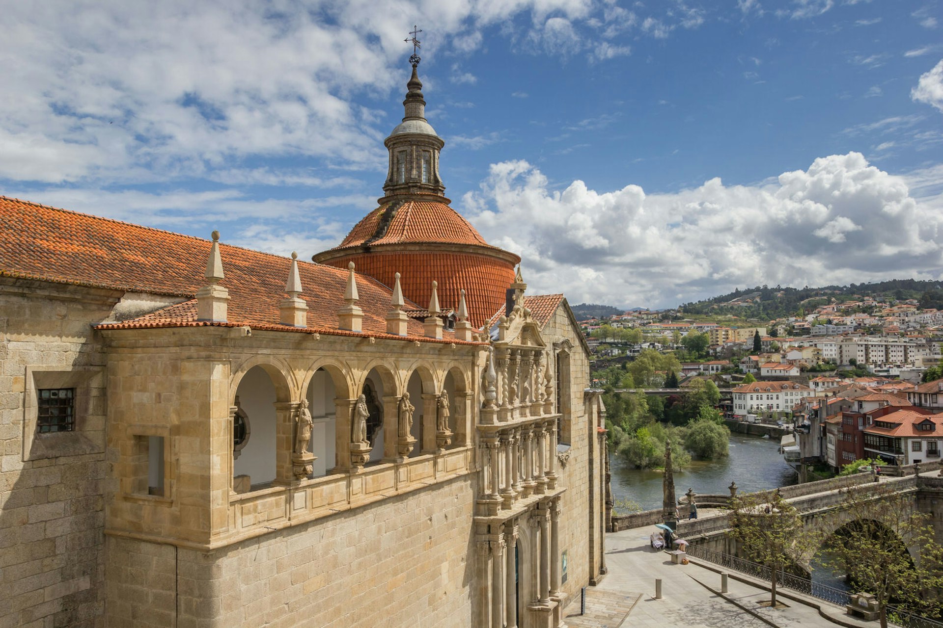 A beautiful stone church, with arched porticoes, a terracotta roof and spire, stands above the pedestrian street; in front of the church, the arched Ponte de São Gonçalo crosses the Tâmega River.