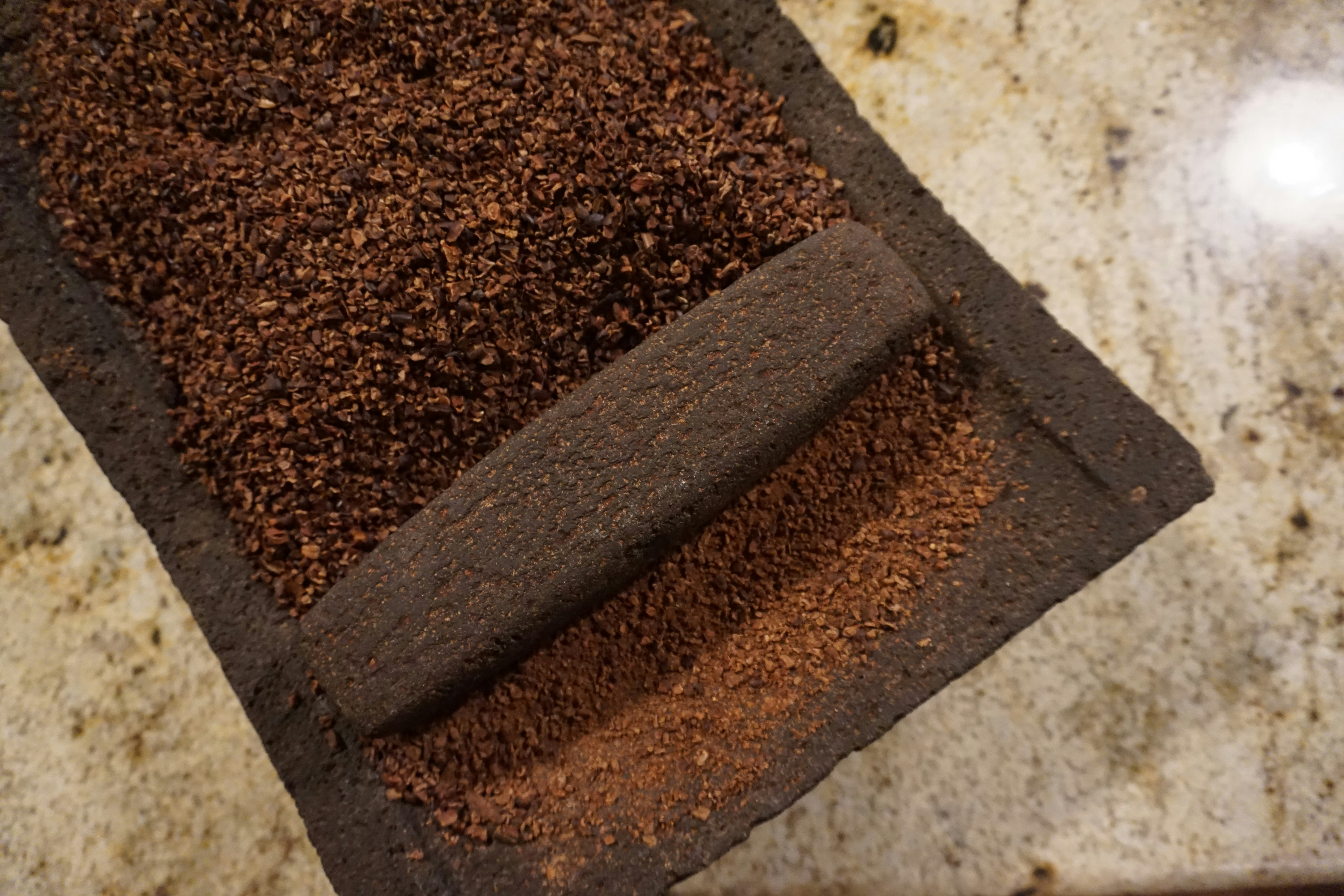 Closeup of a volcanic metate filled with crushed cacao beans in Belize.