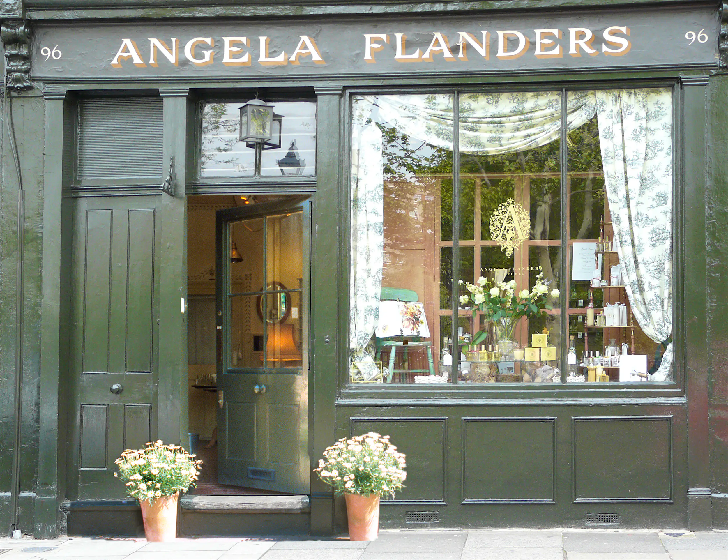 Angela Flanders The green Angela Flanders storefront in east London, with curtained windows displaying flowers and perfume inside.