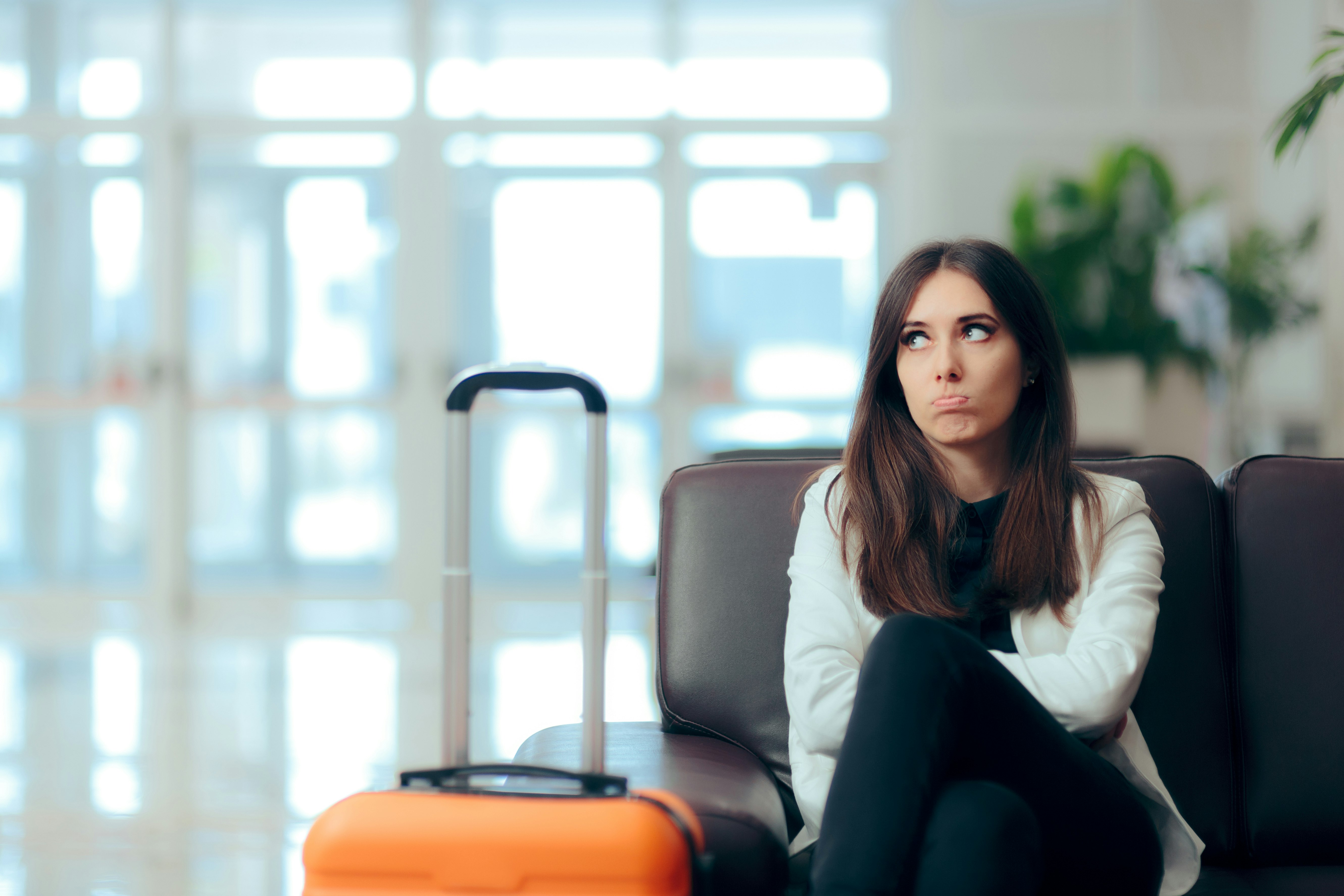 Anxious passenger sits beside her luggage