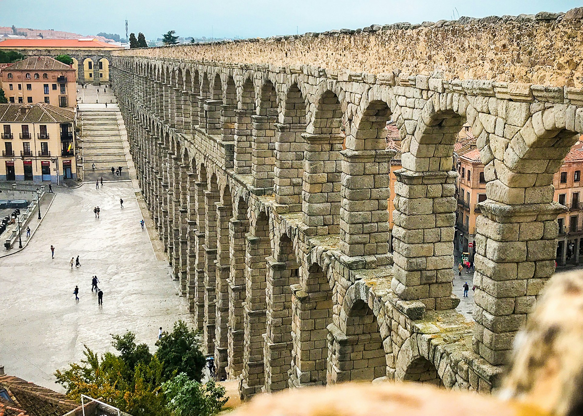 A Roman aqueduct stretches into the distance, with the charming Spanish city of Segovia in its shade.