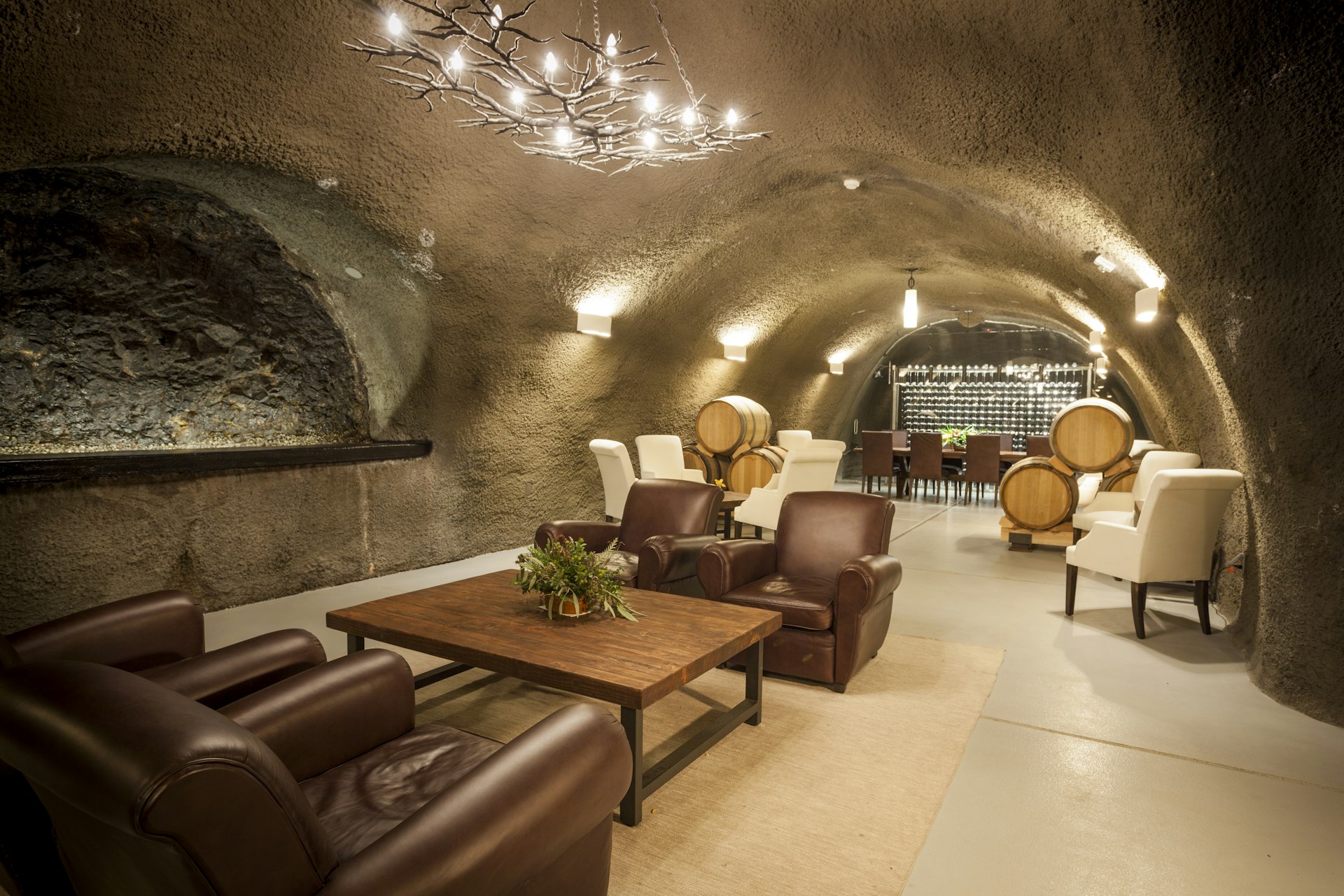 Inside an underground lounge room, with wine barrels and leather seats