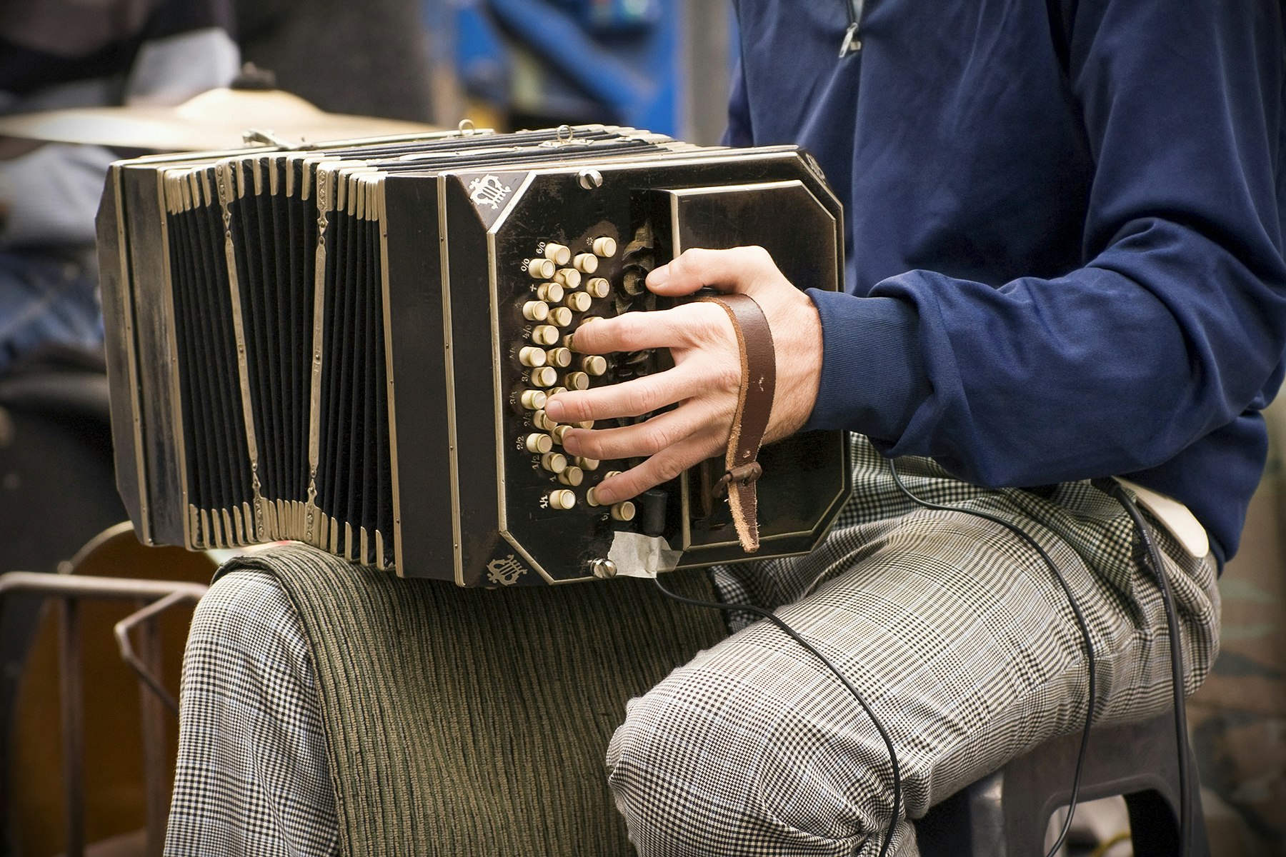 A close-up of a person playing an accordion on their knee in Buenos Aires