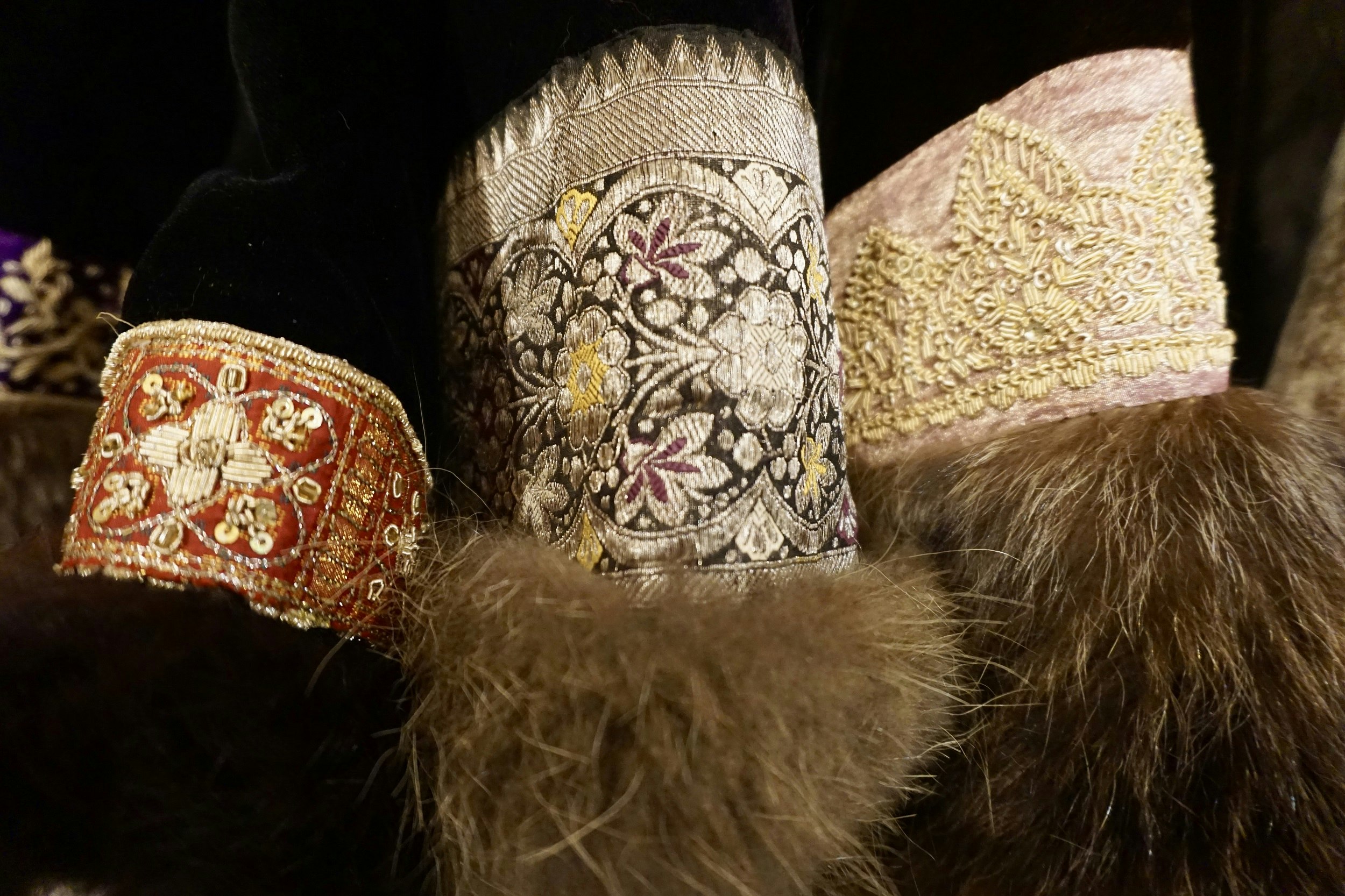 Embroidered bracelets of reds, browns and yellows, some with fur trim.