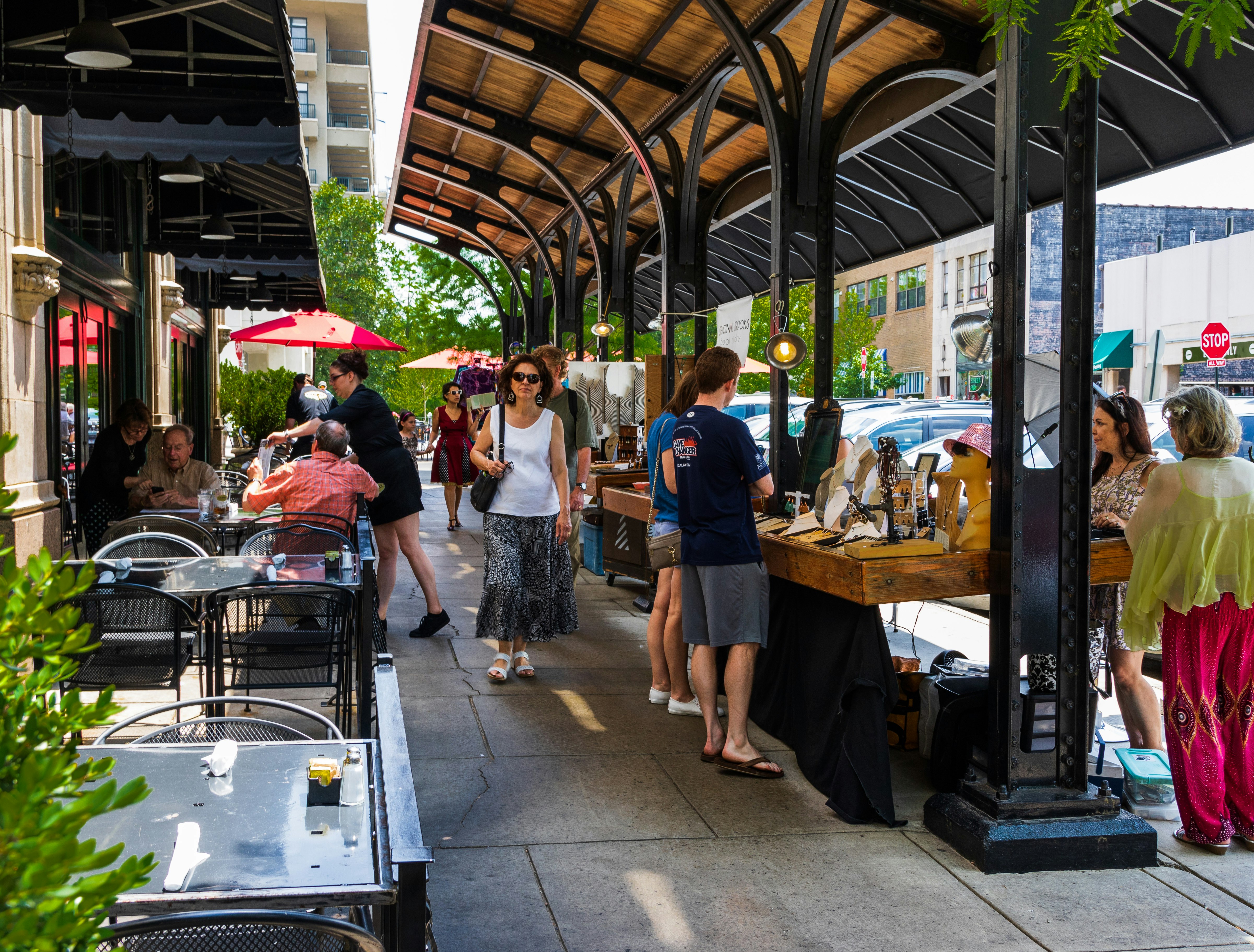 Streetside market stalls near a dining area on Grove Arcade