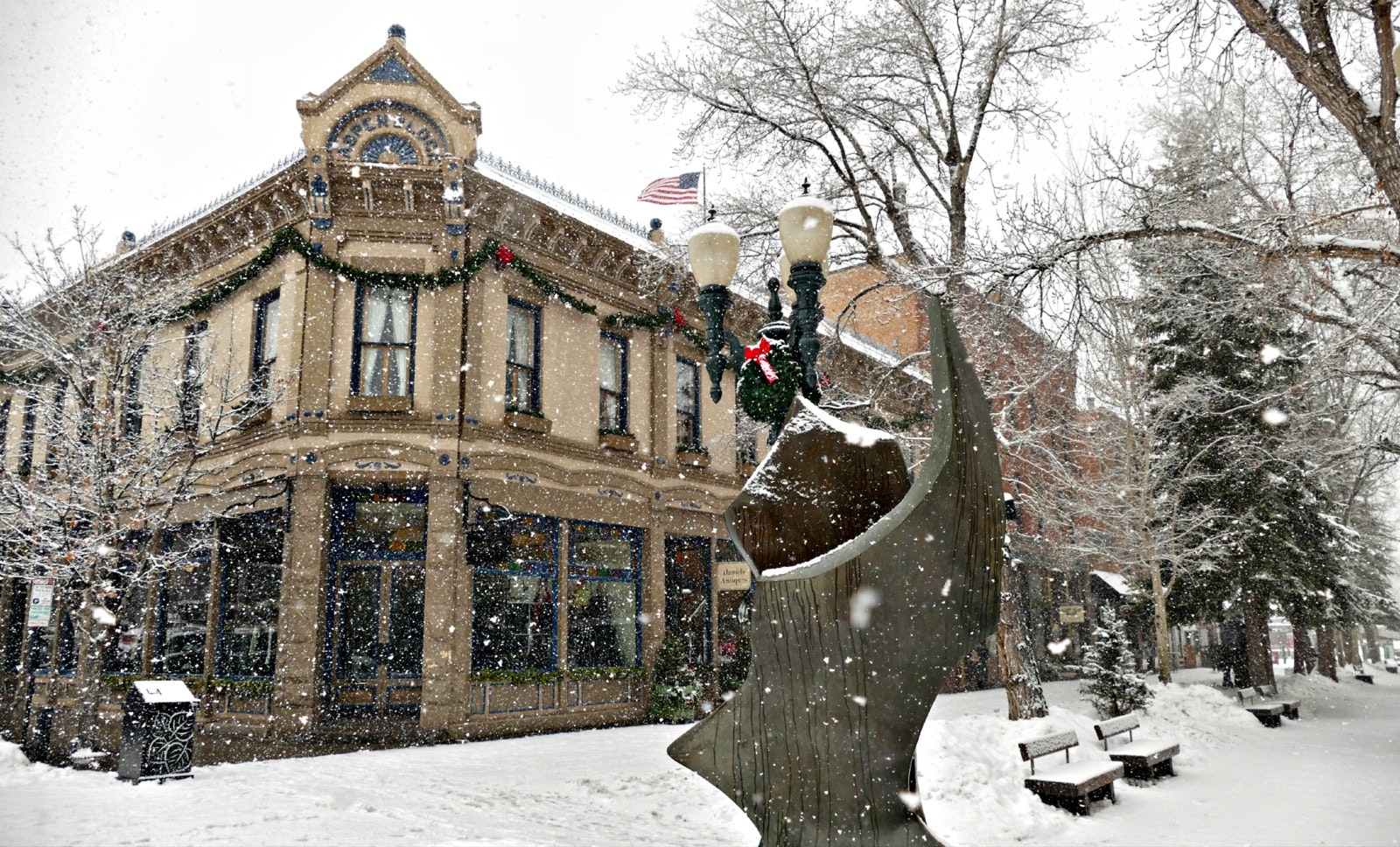 A downtown Aspen, Colorado building in the snow with a sculpture out front