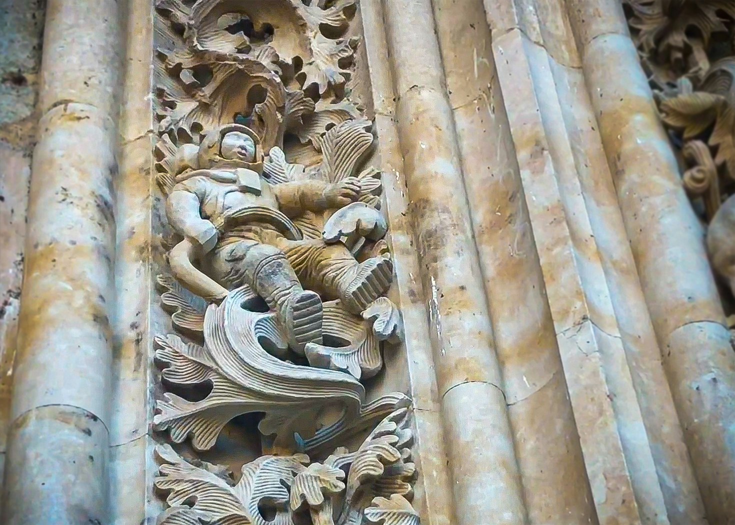 A stone sculpture of an astronaut on a pillar in Salamanca's new cathedral