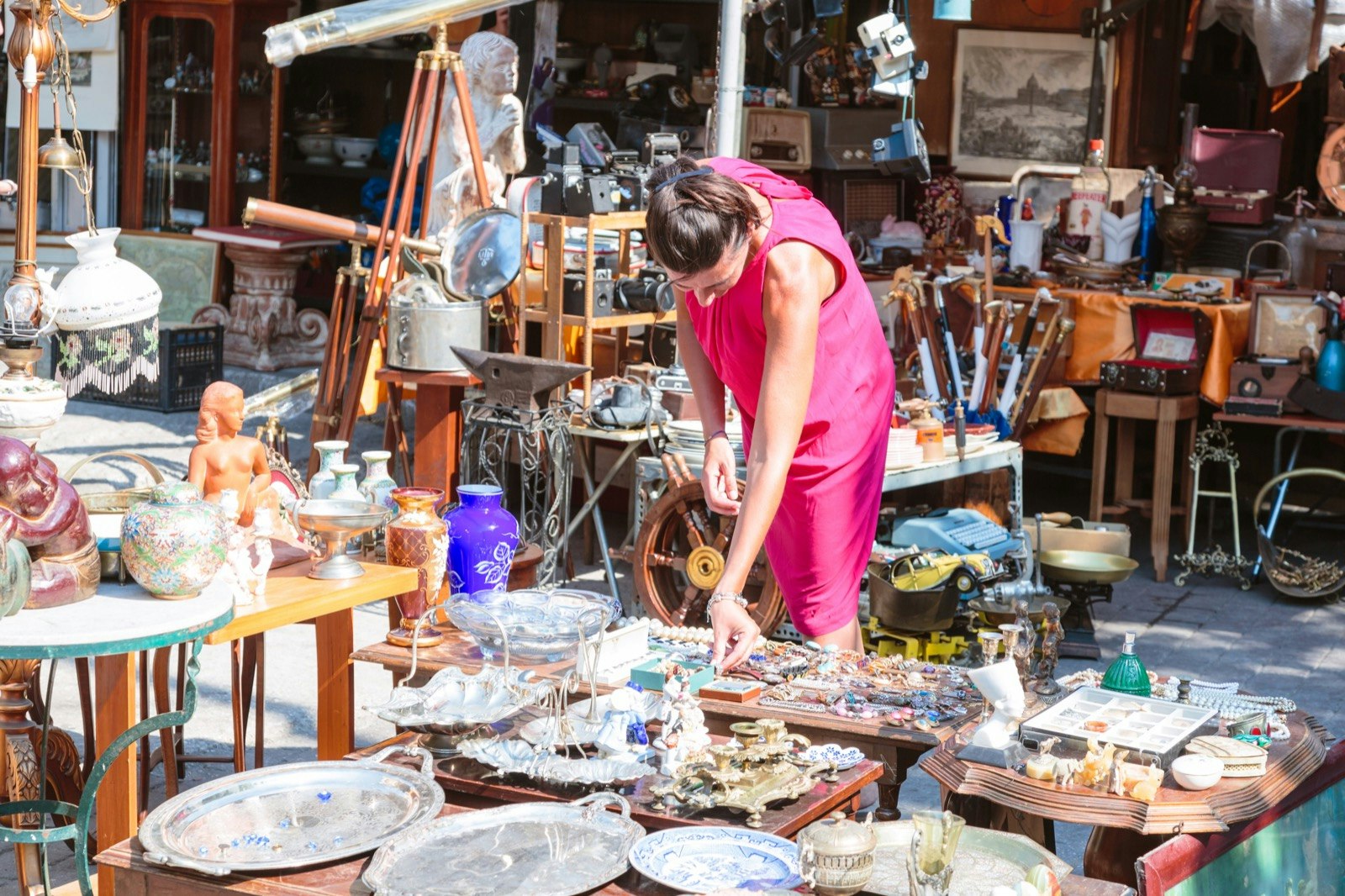 Woman in pink dress shops at a flea market in Athens