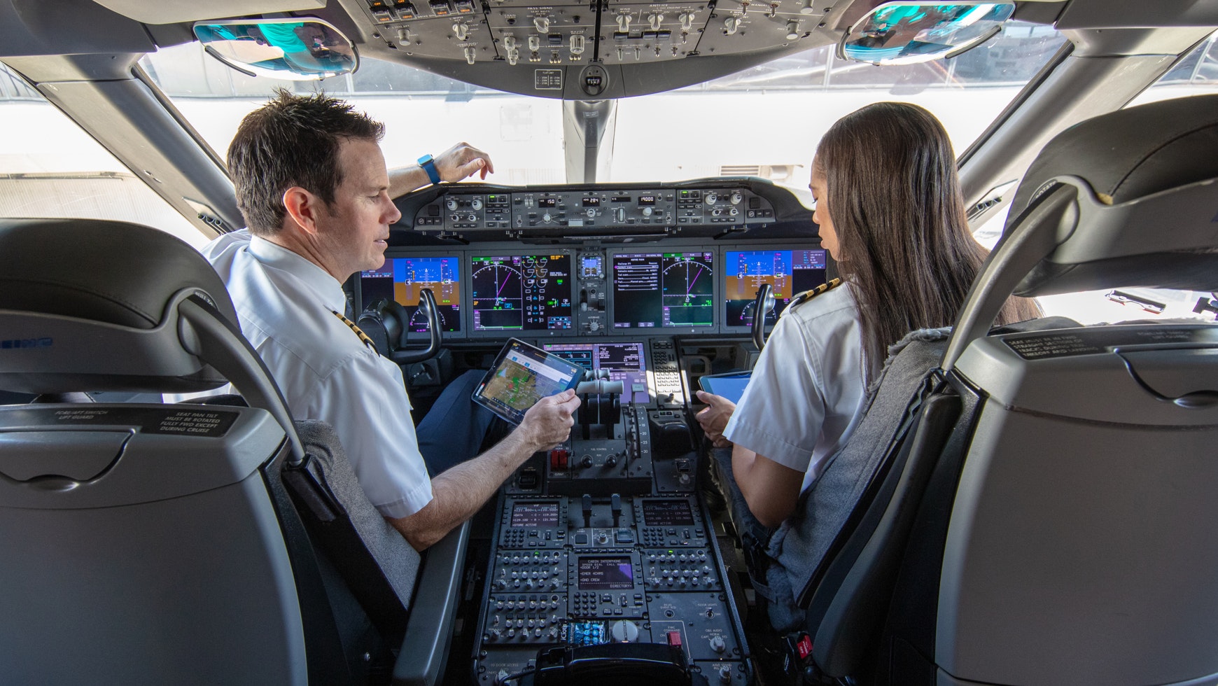 Male and female pilots at the flight deck.jpg