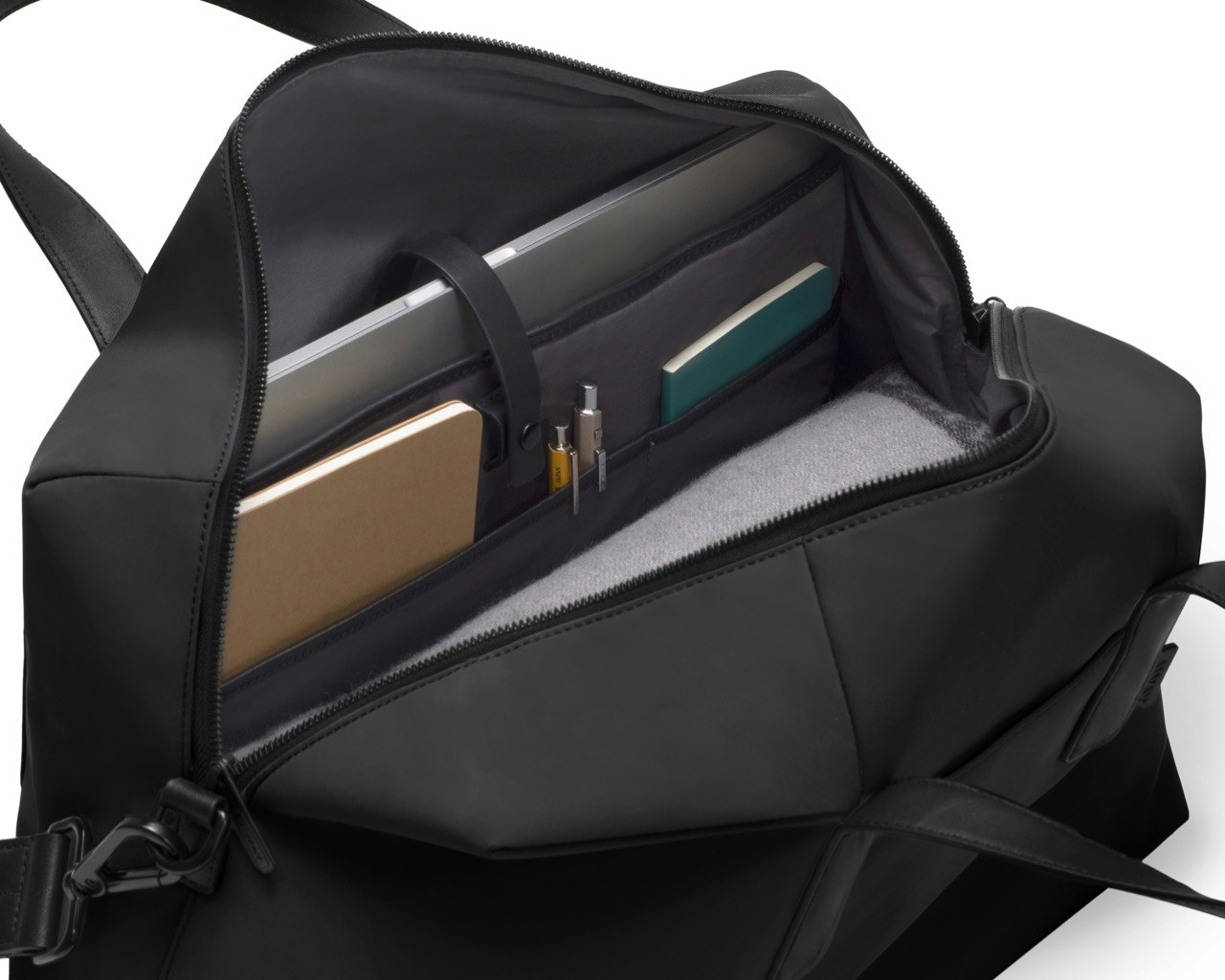 Away's black Everywhere bag, open to show clothes, notebooks, pens, and a laptop
