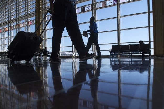 People walking in silhouette through an airport