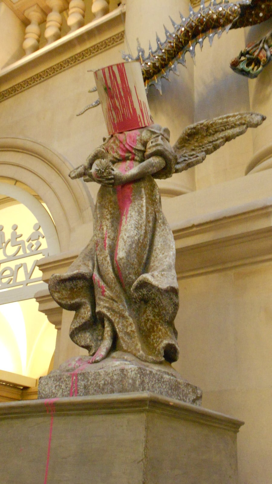 A sculpture by Banksy at Bristol Museum and Art Gallery; angel with a paint bucket on its head