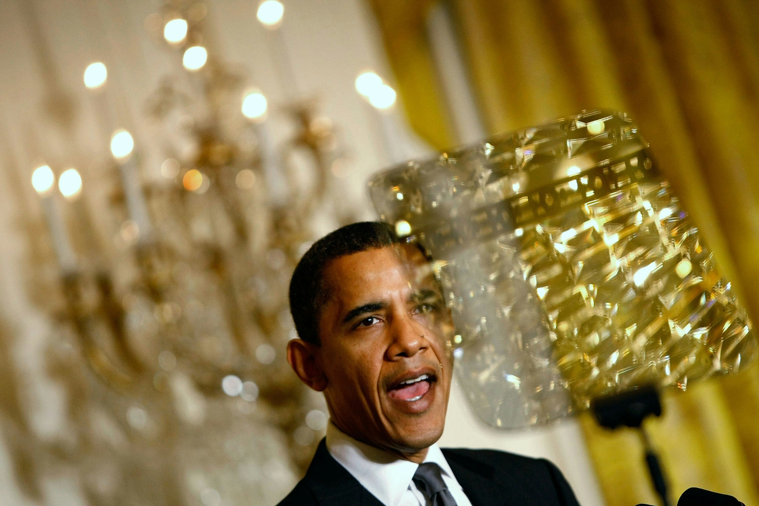 Barack Obama in front of a chandelier